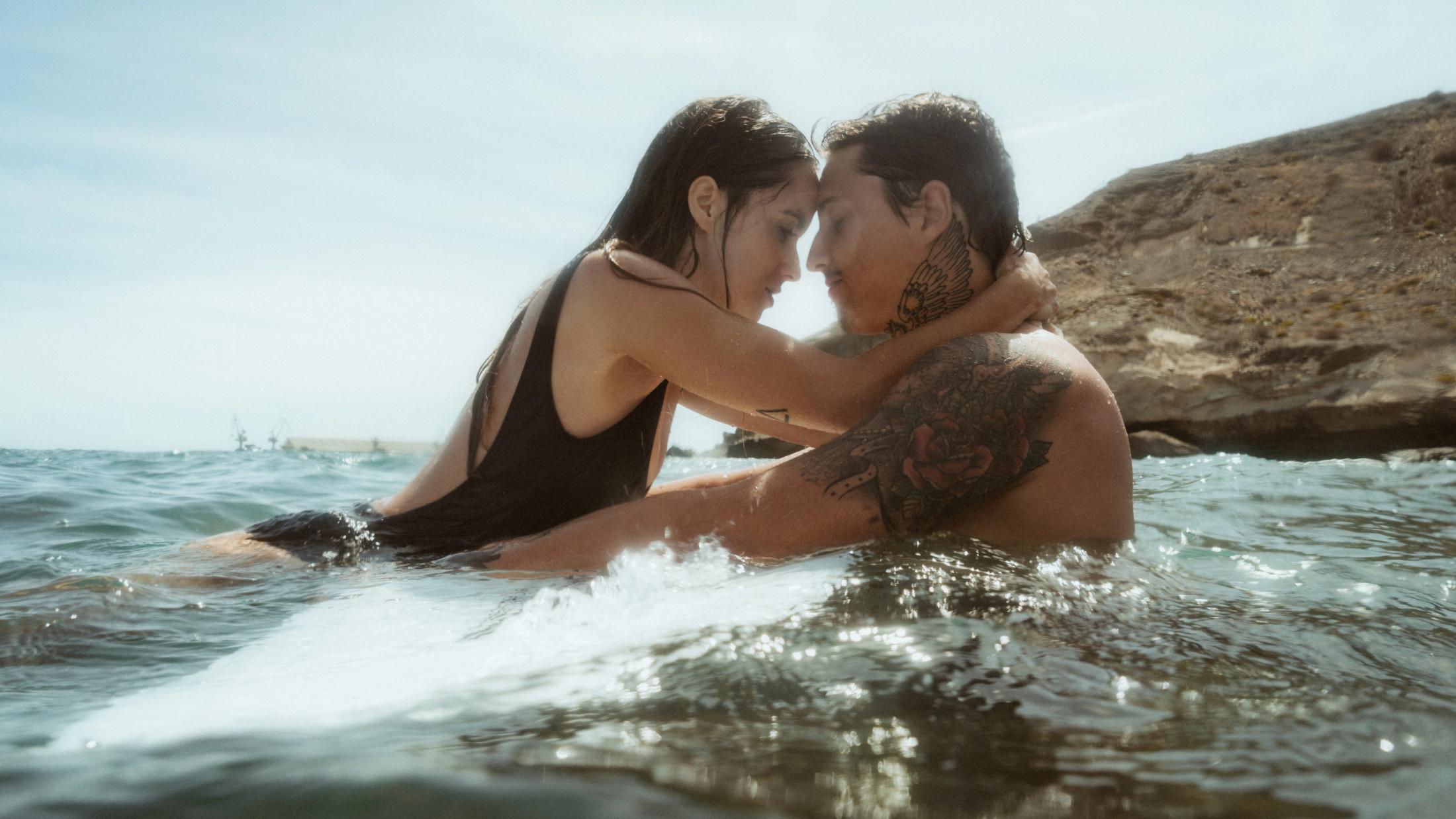 Angela und Ivan halten sich im Wasser nahe der felsigen Küste.