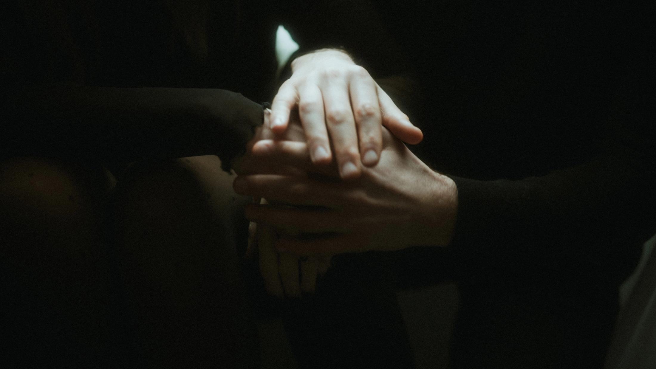 Lorelai and Steffen holding hands in a hotel room