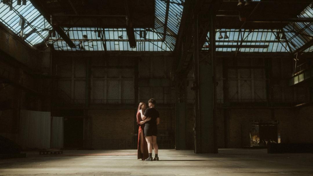 Noah und Michèle umarmen sich in der Mitte der riesigen dunklen Mahalla-Halle.