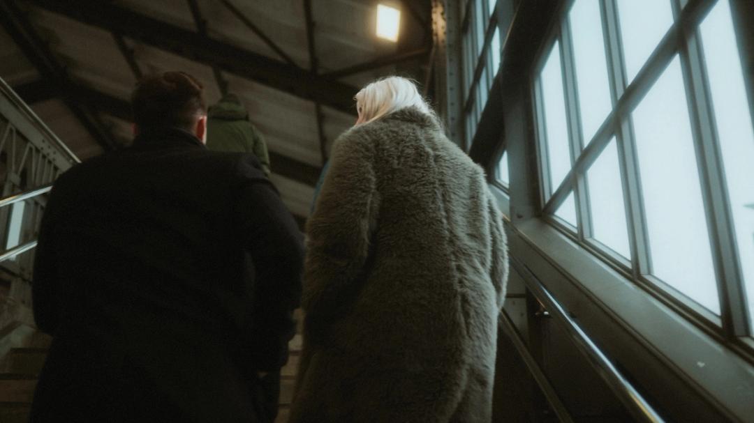 Lorelai and Steffen walk through the covered bridge toward the station.