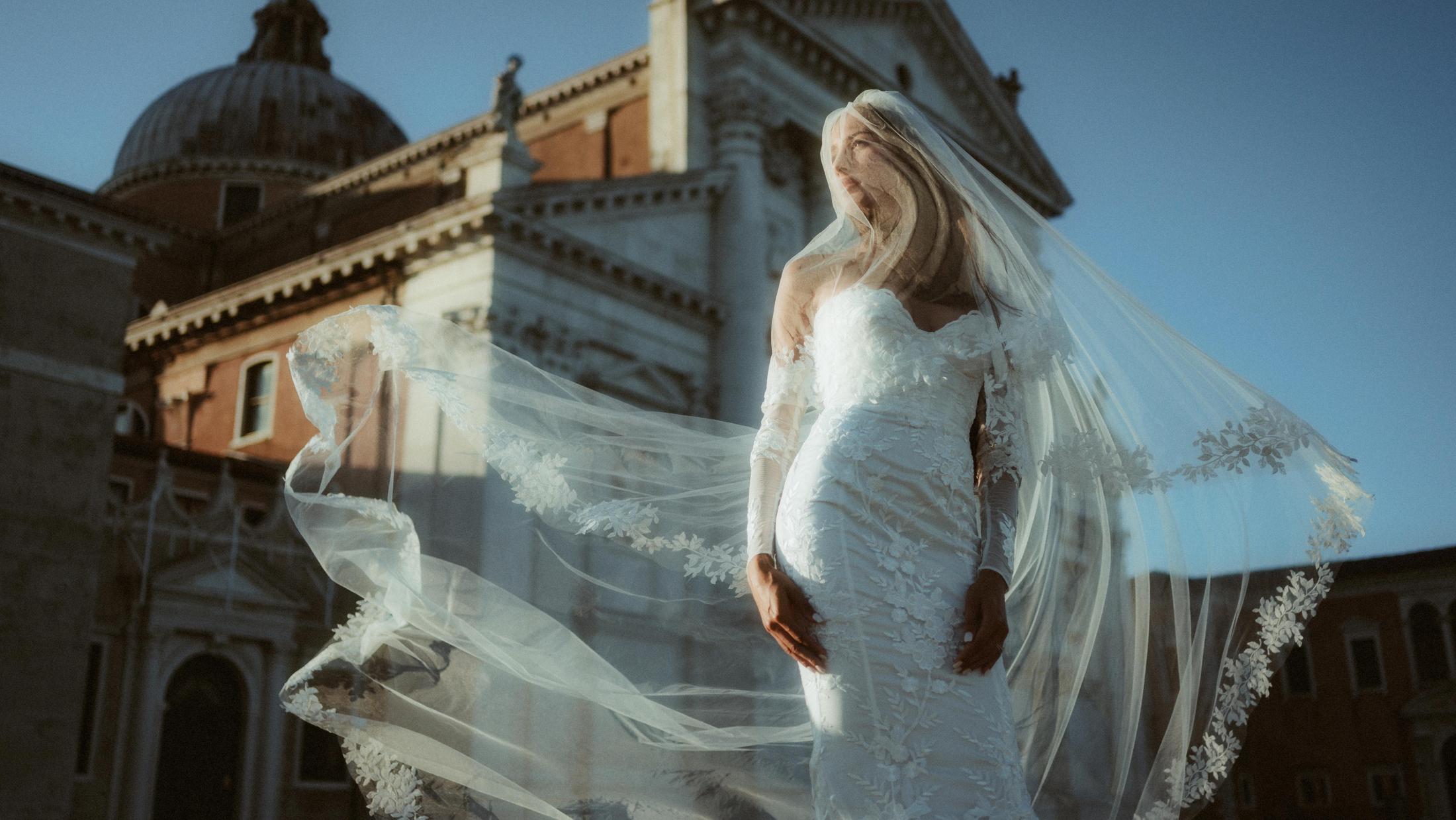 A layered portrait makes the bride and her veil appear twice against Venetian architecture.