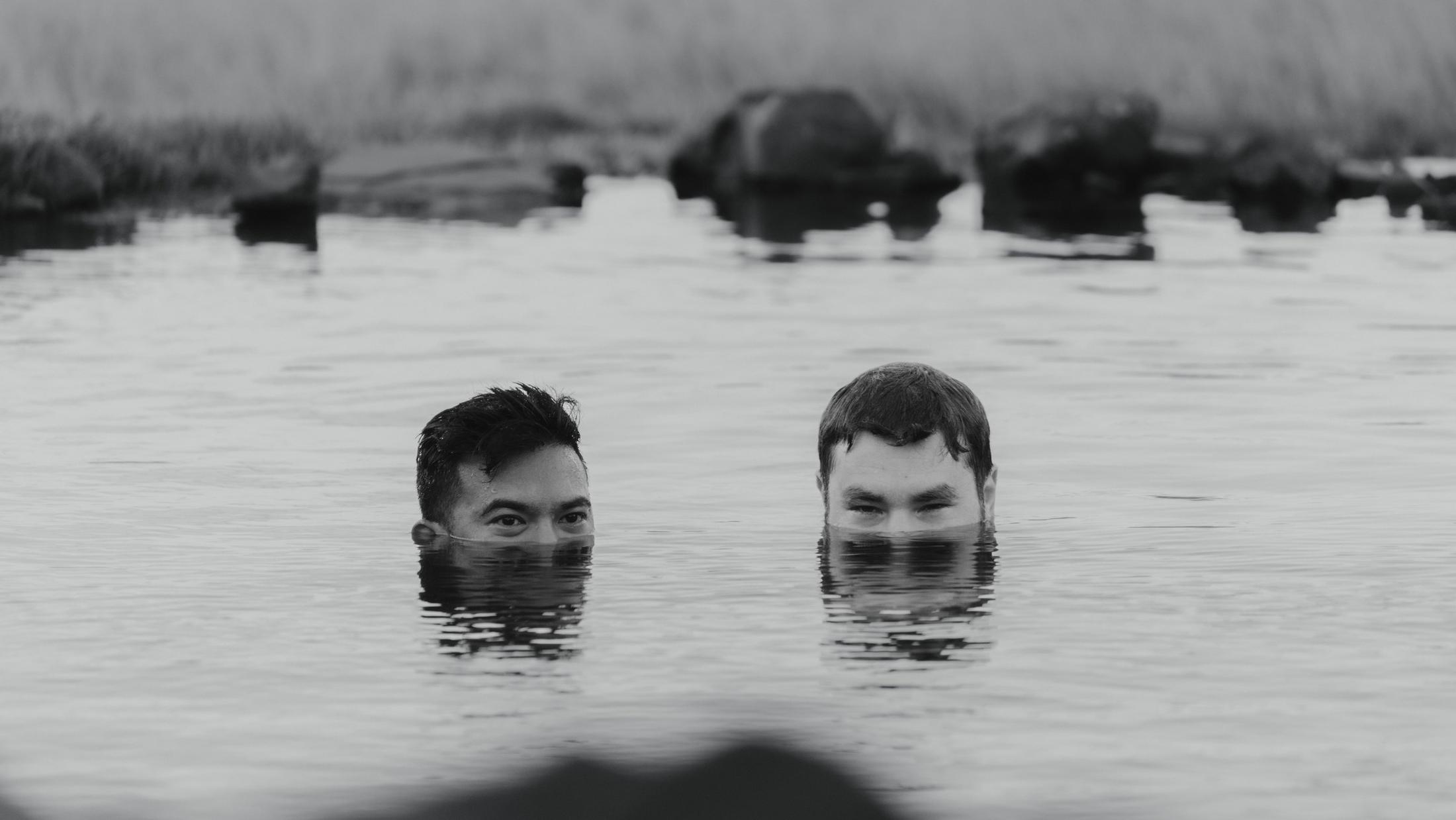 Black-and-white photograph of two heads above the surface of the water.