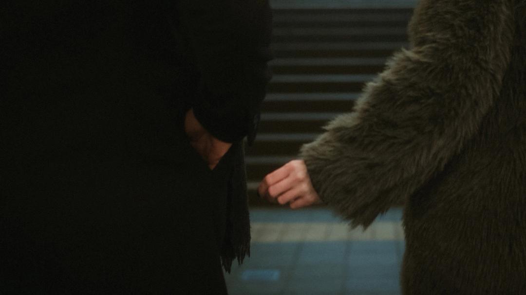 Close view of Lorelai and Steffen holding hands while climbing station stairs.