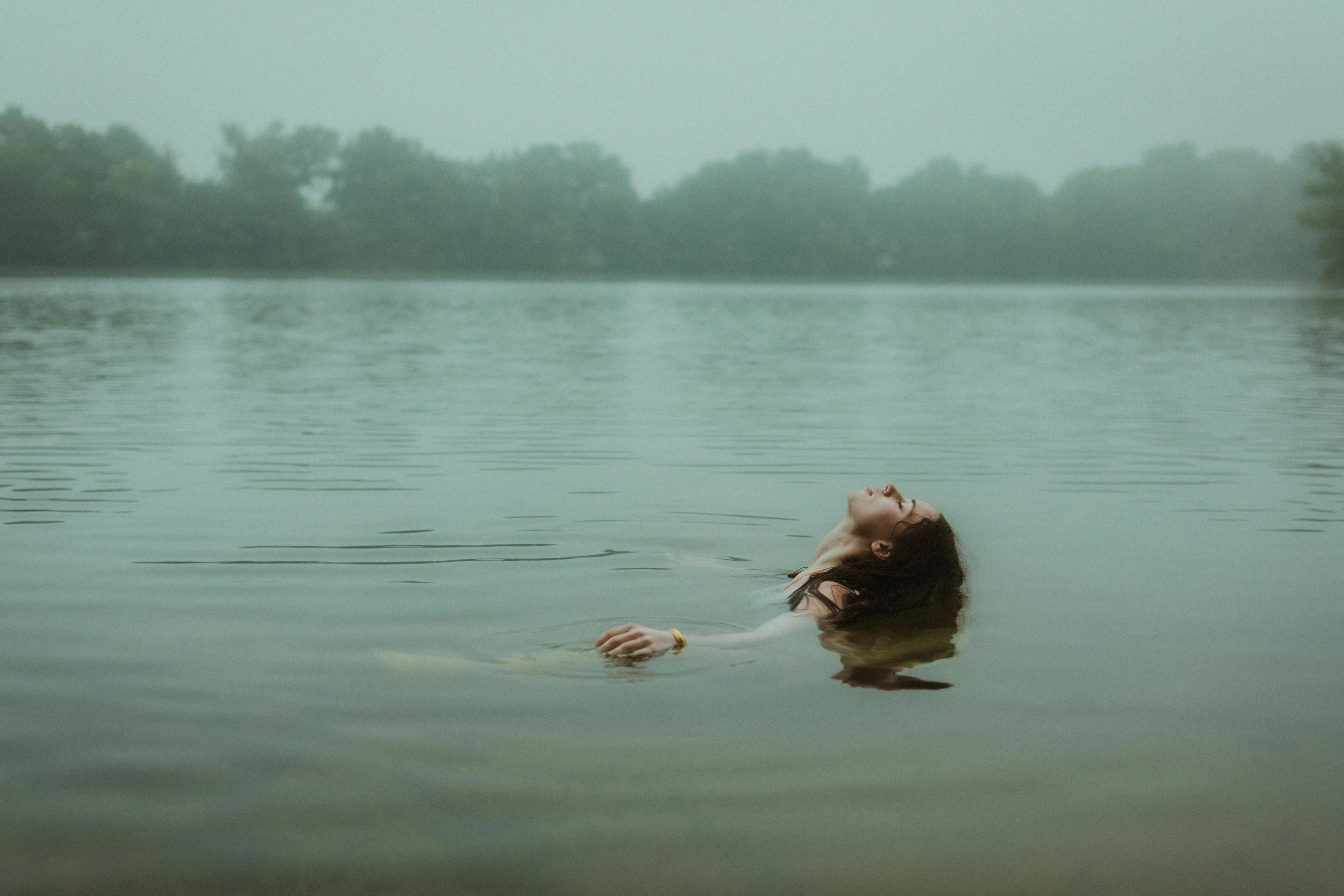 A lone figure held by the open surface of a lake