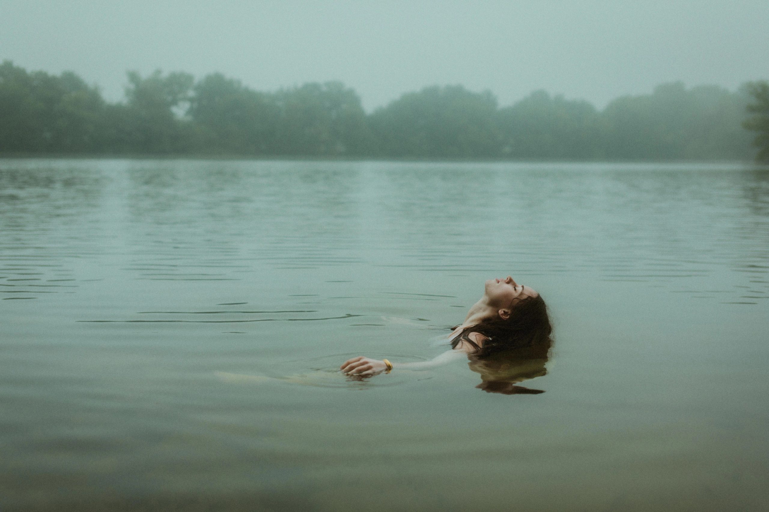 A lone figure held by the open surface of a lake