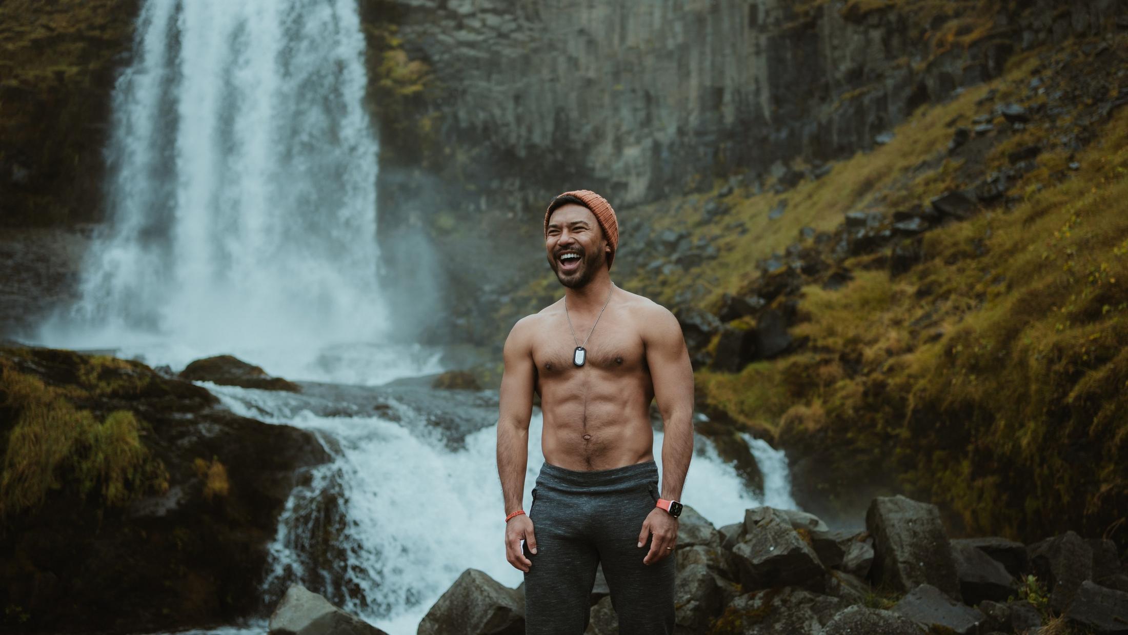 A person laughing beside falling water.