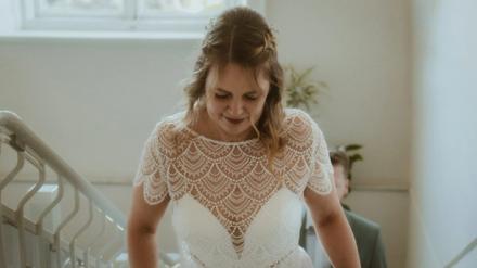Kira blickt in einem ruhigen Portrait in ihrem Hochzeitskleid nach unten
