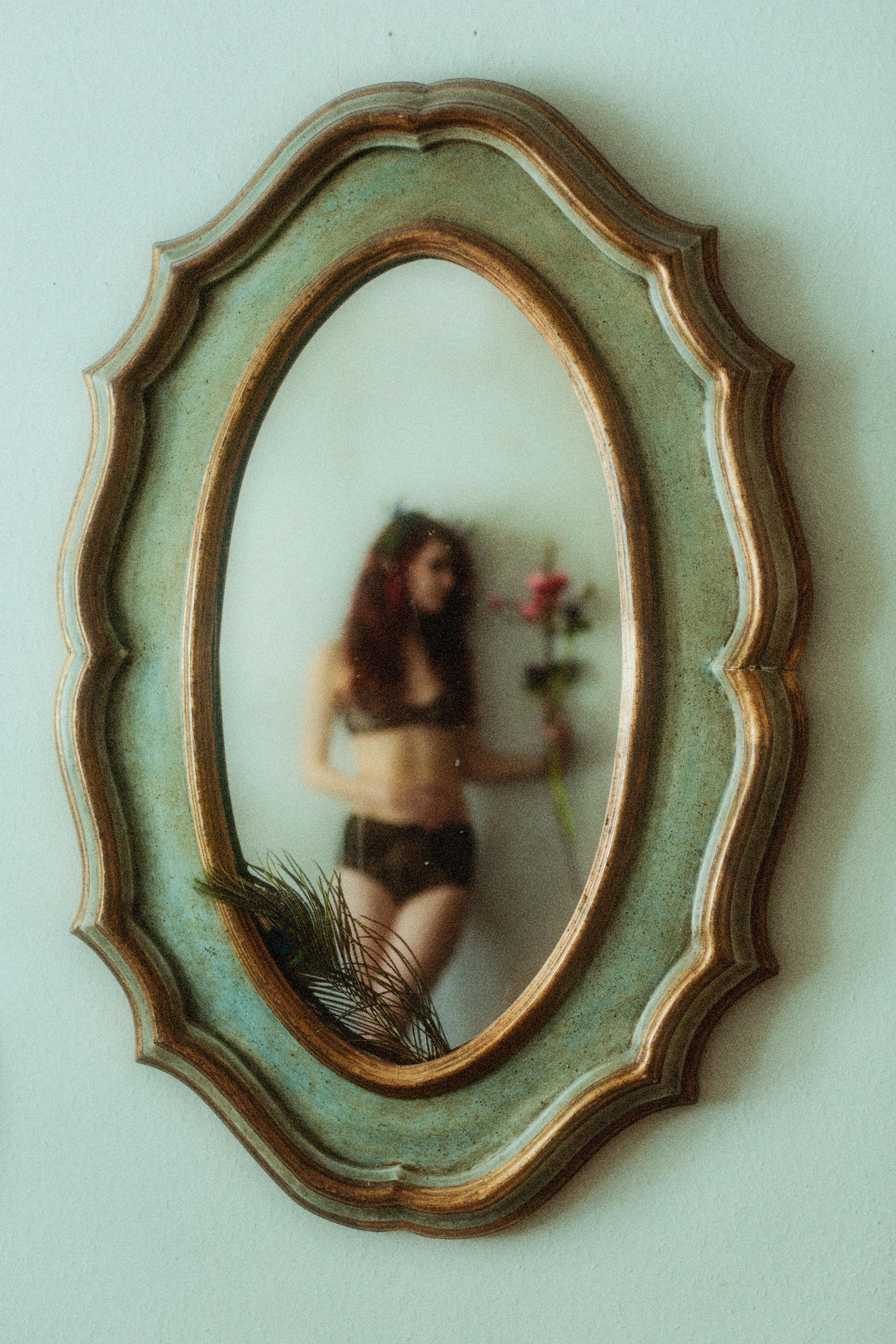 A face reflected inside a small wall mirror