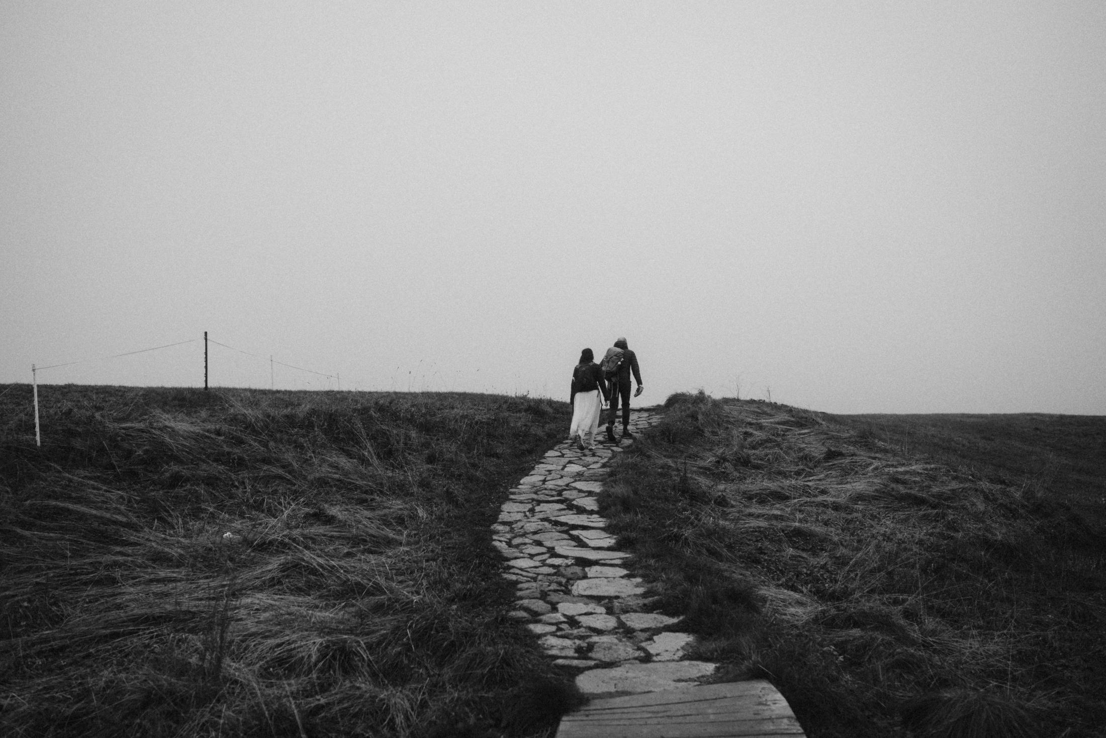 A stone path leading uphill through dense fog.