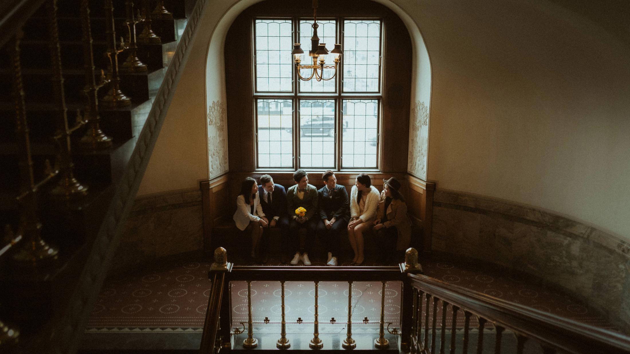 Kevin, Terence and their friends stand on an upper landing inside Copenhagen City Hall.
