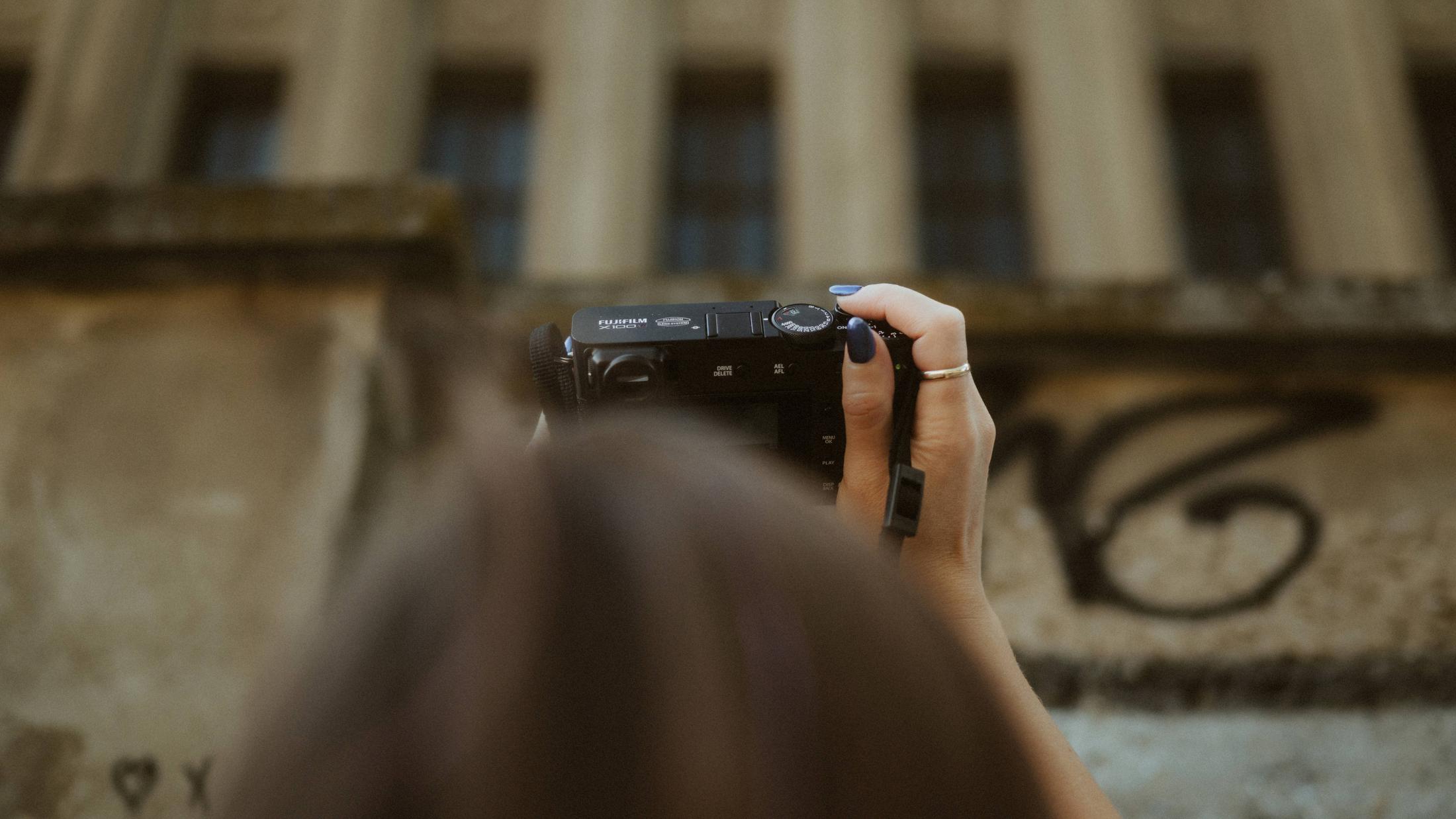 Michèle raising her camera to photograph the Berlin facade.