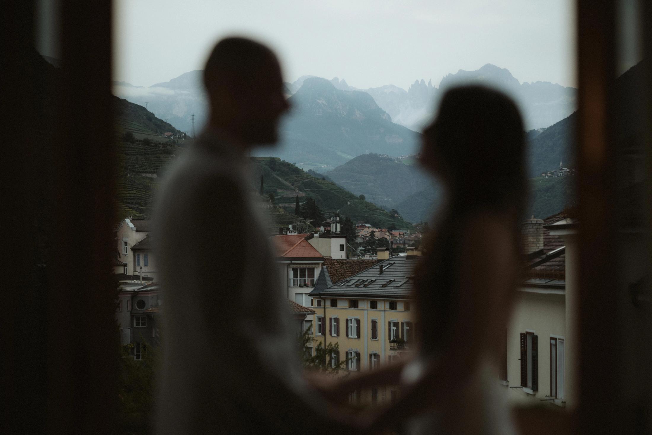 Soft-focus view of Jana and Steffen close together at the hotel window.