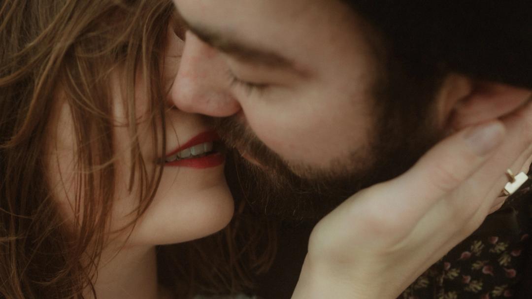 Extreme close-up of Anni and Daniel kissing, with her red lipstick visible.