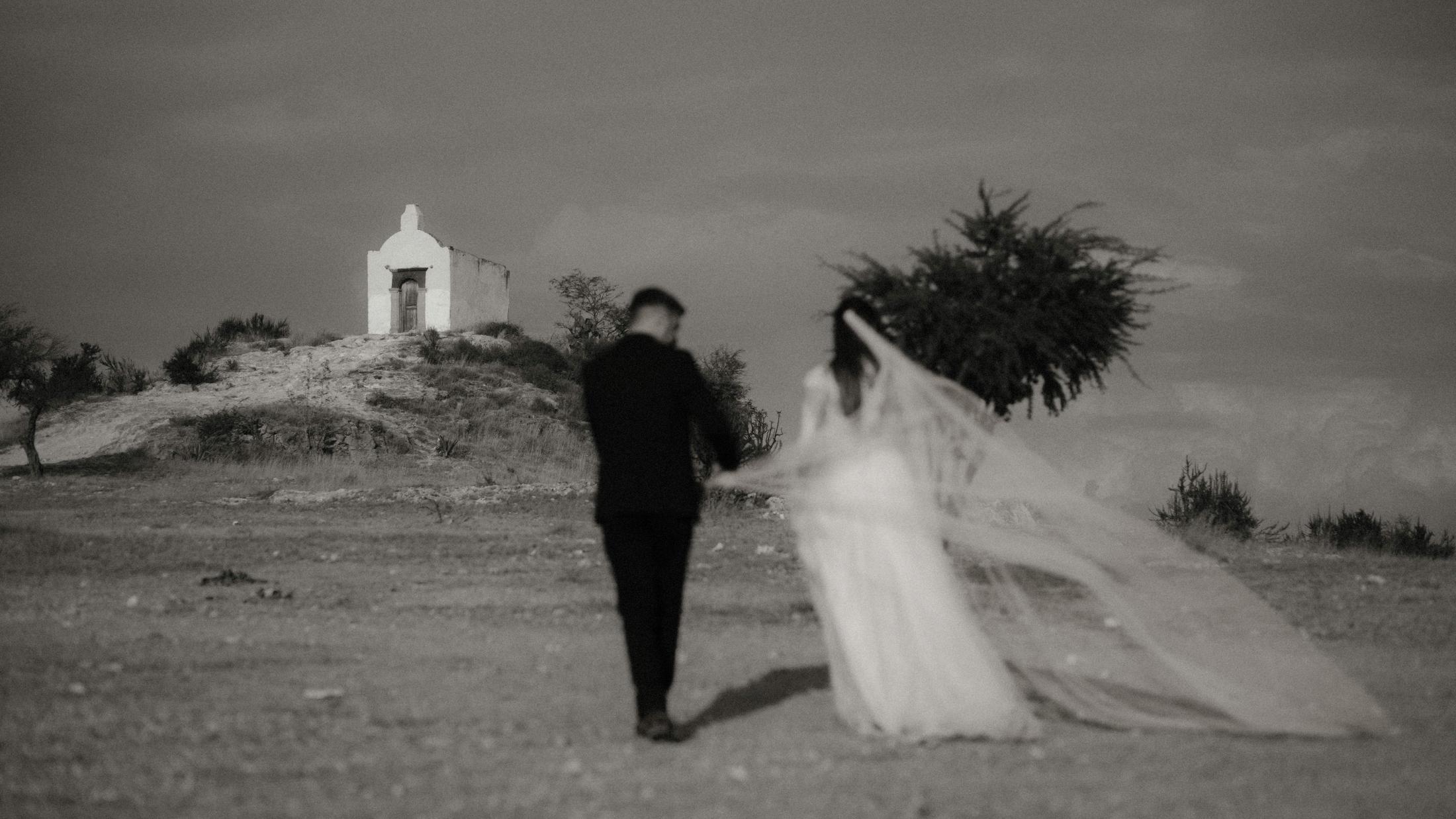 Anna und Nahuel gehen auf eine weiße Kapelle zu.