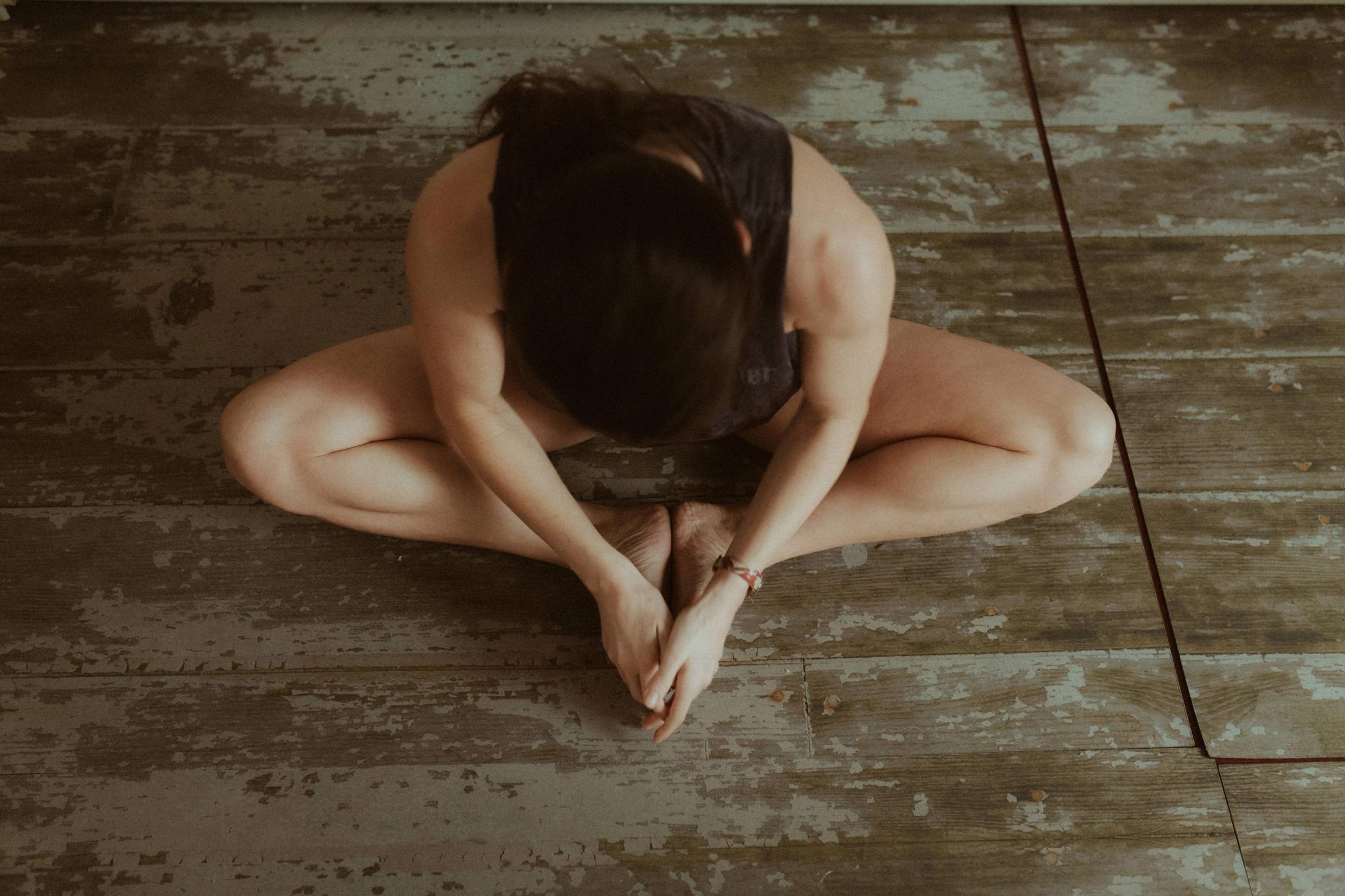 Maya folded into a seated stretch, photographed from above.