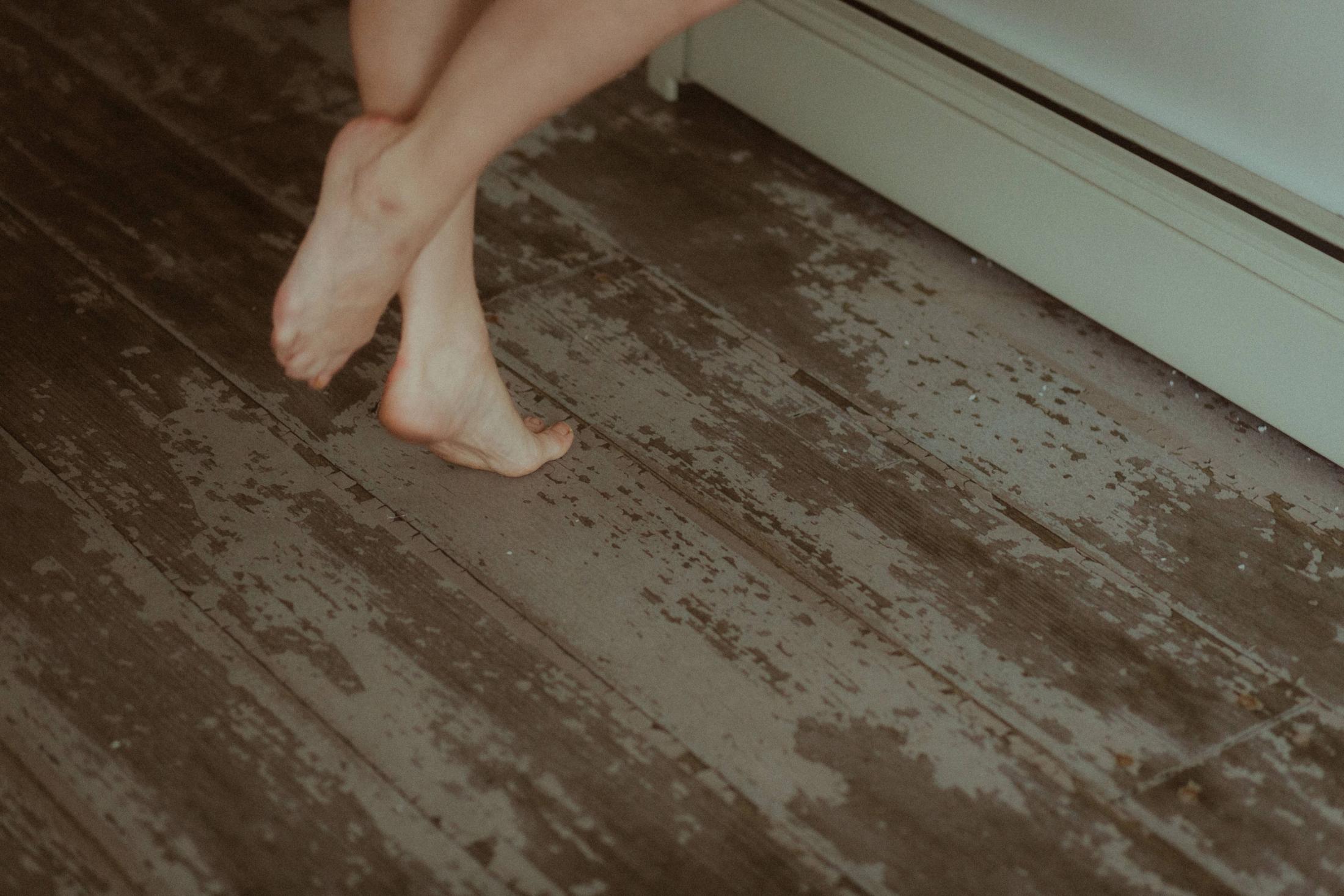 Maya’s bare feet crossing the worn wooden floor.