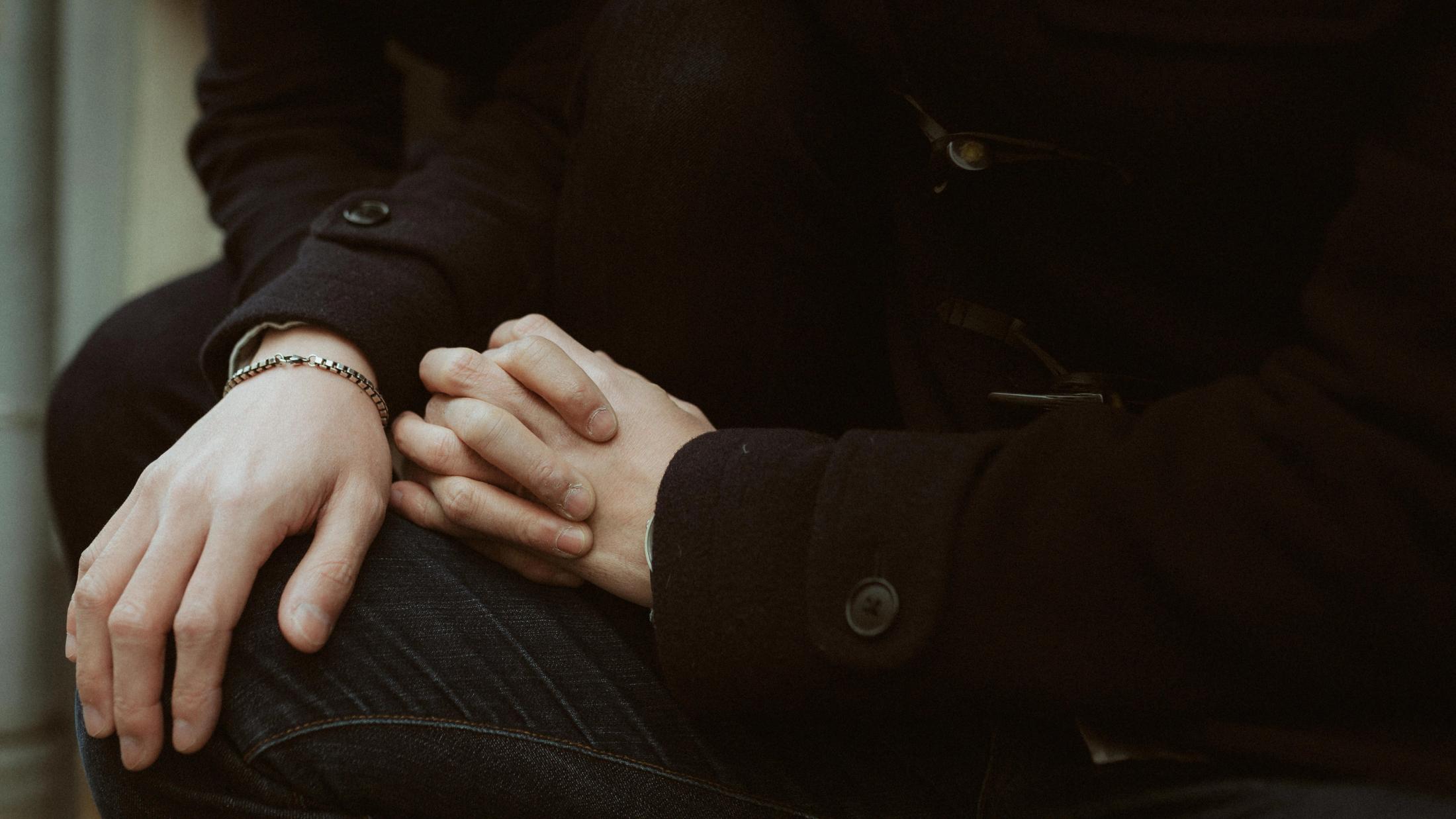 A close view of Kevin and Terence’s hands resting beside each other.