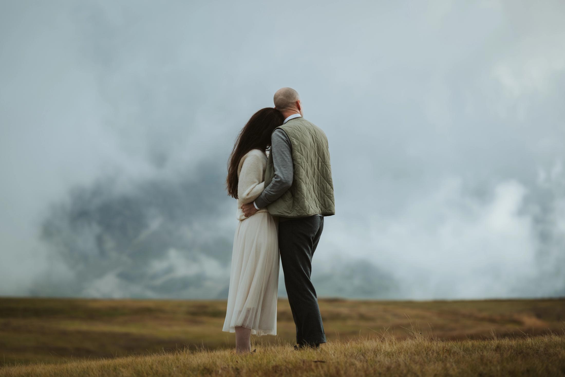 Jana and Steffen standing together and looking toward the clouds.