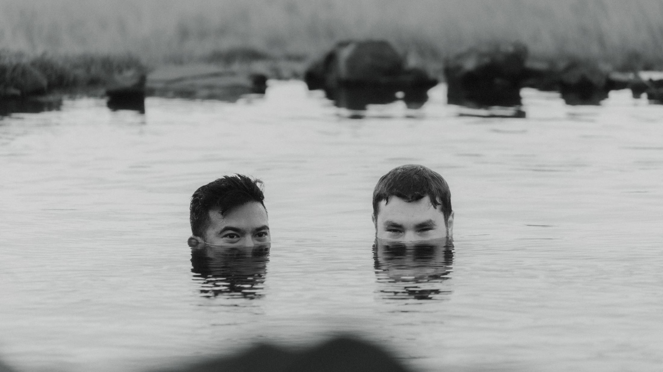 Schwarzweiß-Aufnahme von Kris und Ilya, nur ihre Köpfe ragen aus dem Wasser der heißen Quelle.