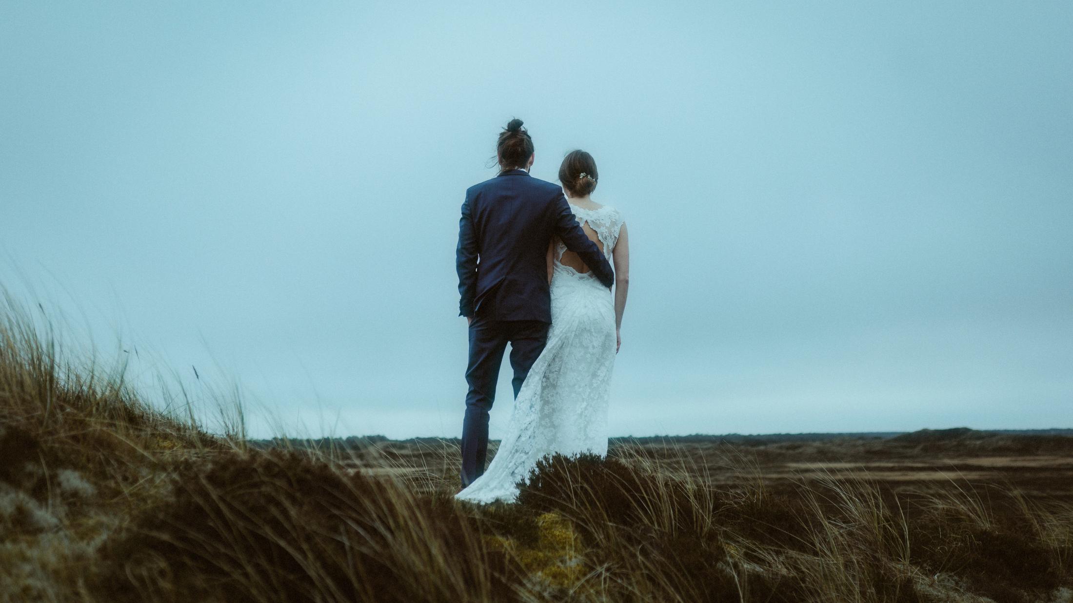 Nina und Torben gehen unter hellem Himmel Arm in Arm gemeinsam davon.