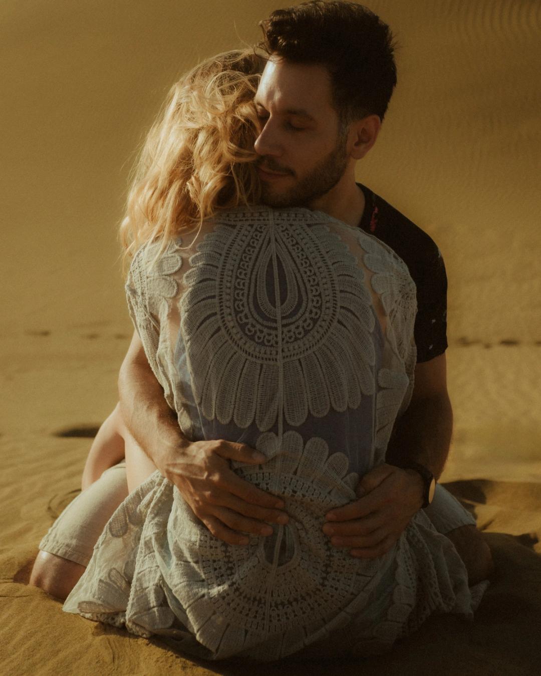 Katja embracing David with her patterned cardigan facing the camera.