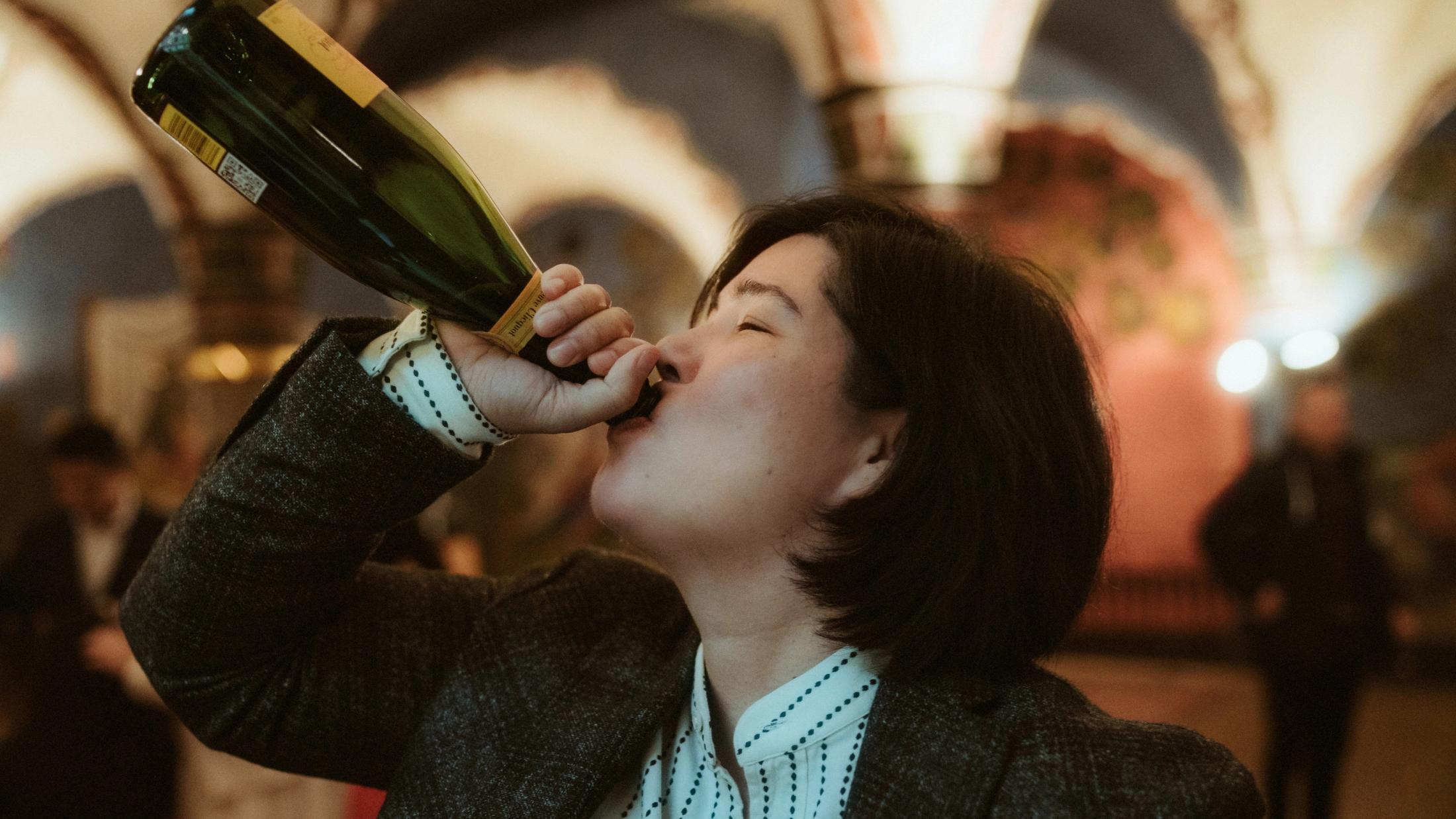 Pia drinking champagne directly from the bottle