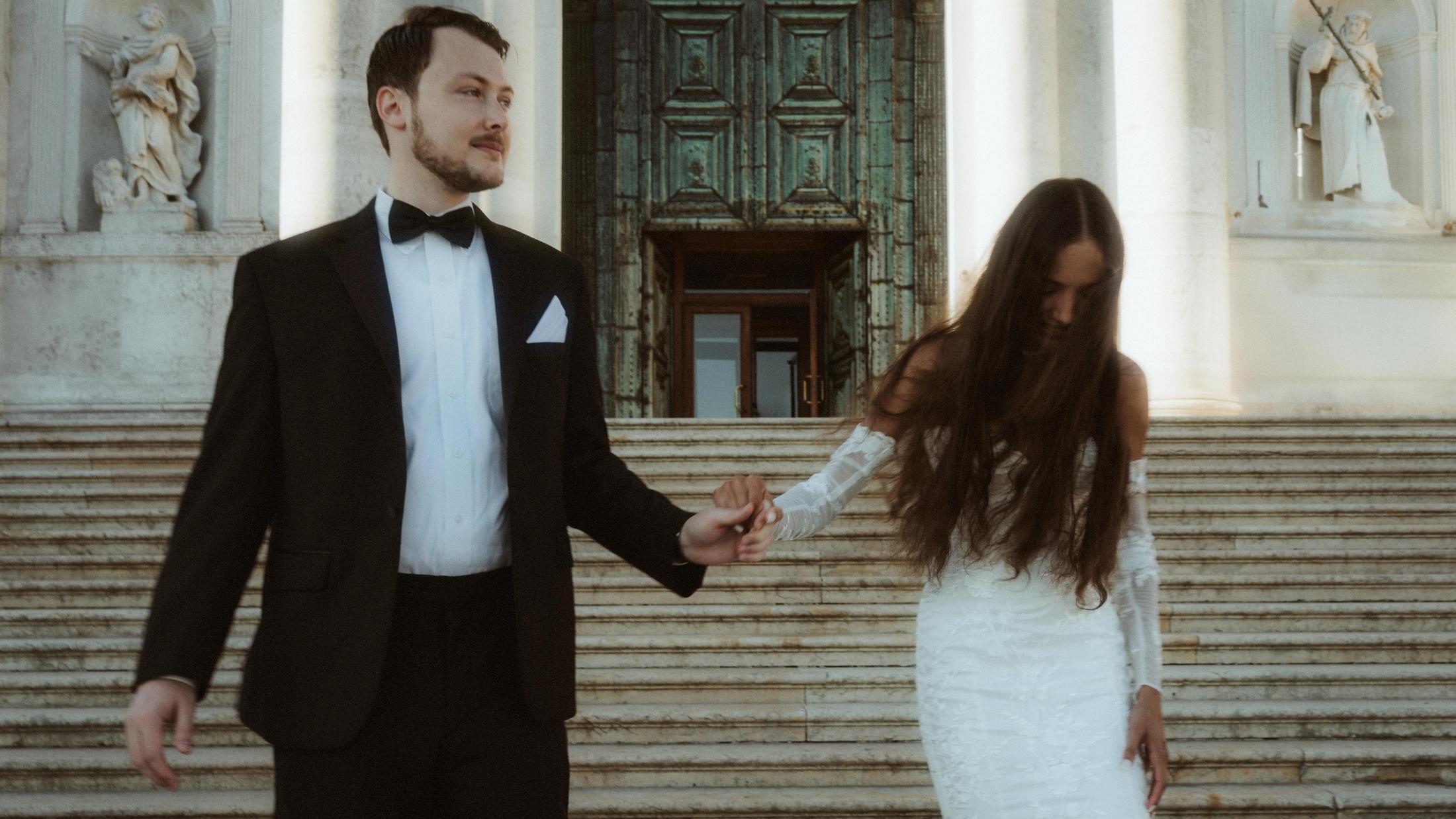 The couple walks down the church steps hand in hand.
