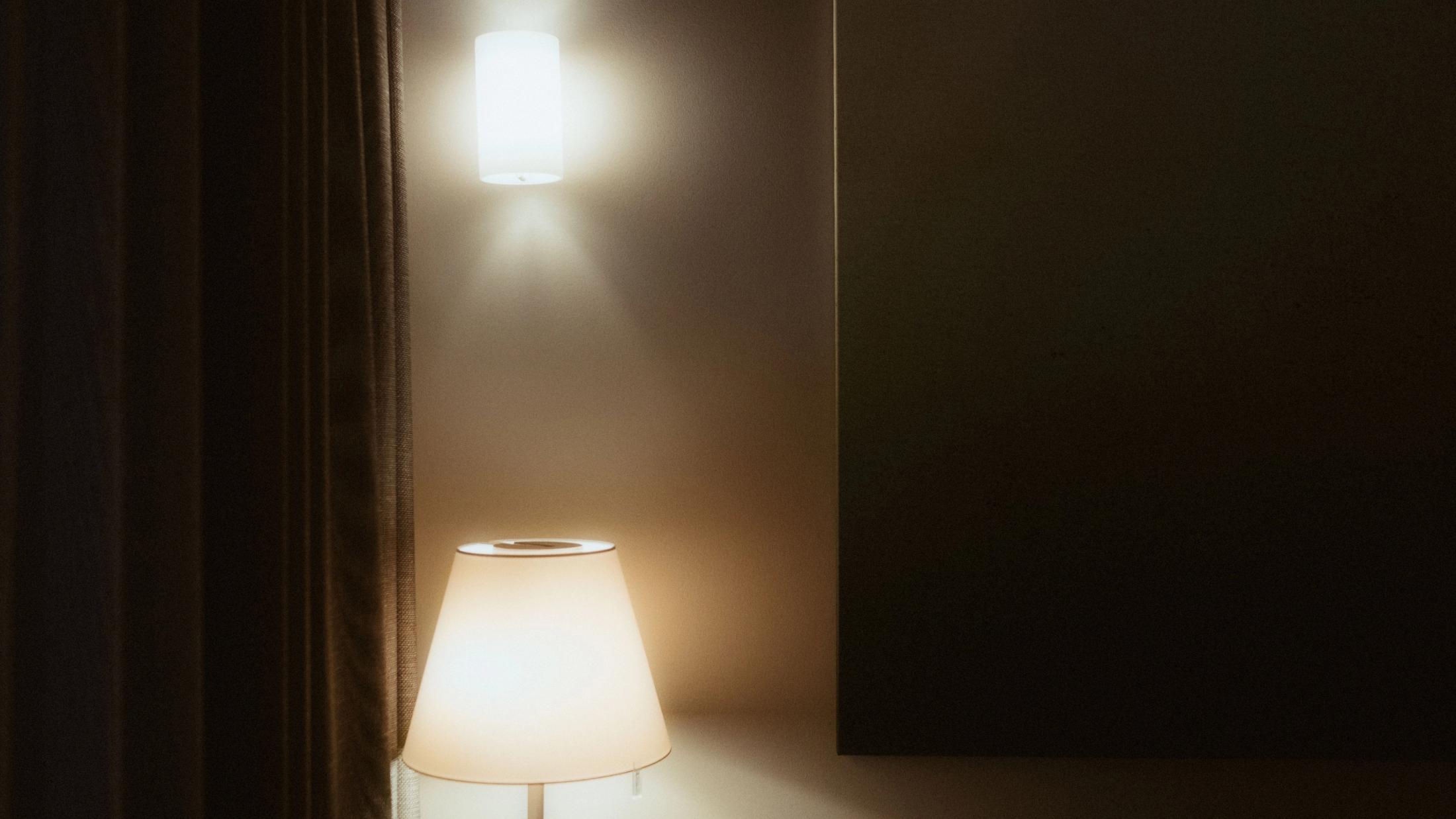 Two warm lamps glowing against a dark apartment wall