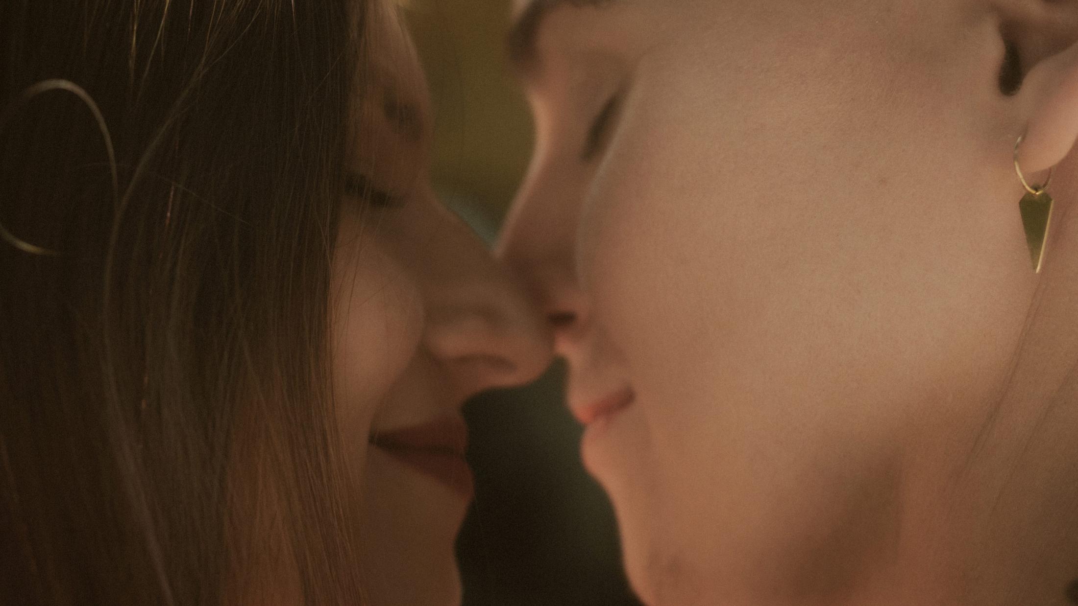 Noah and Michèle's faces close together in side profile.