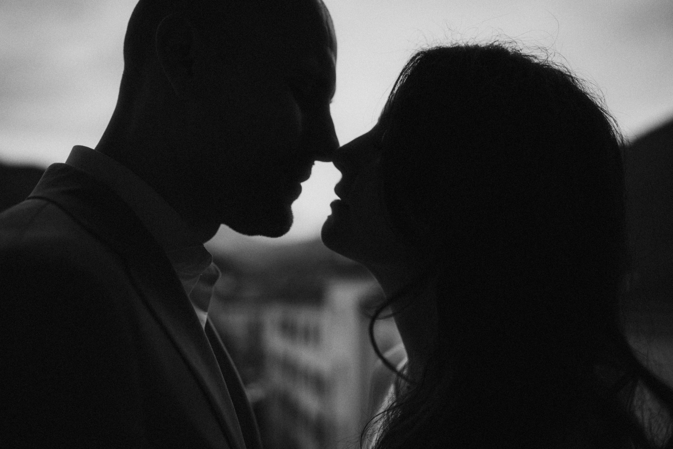 Close silhouette of Jana and Steffen facing each other by the window.