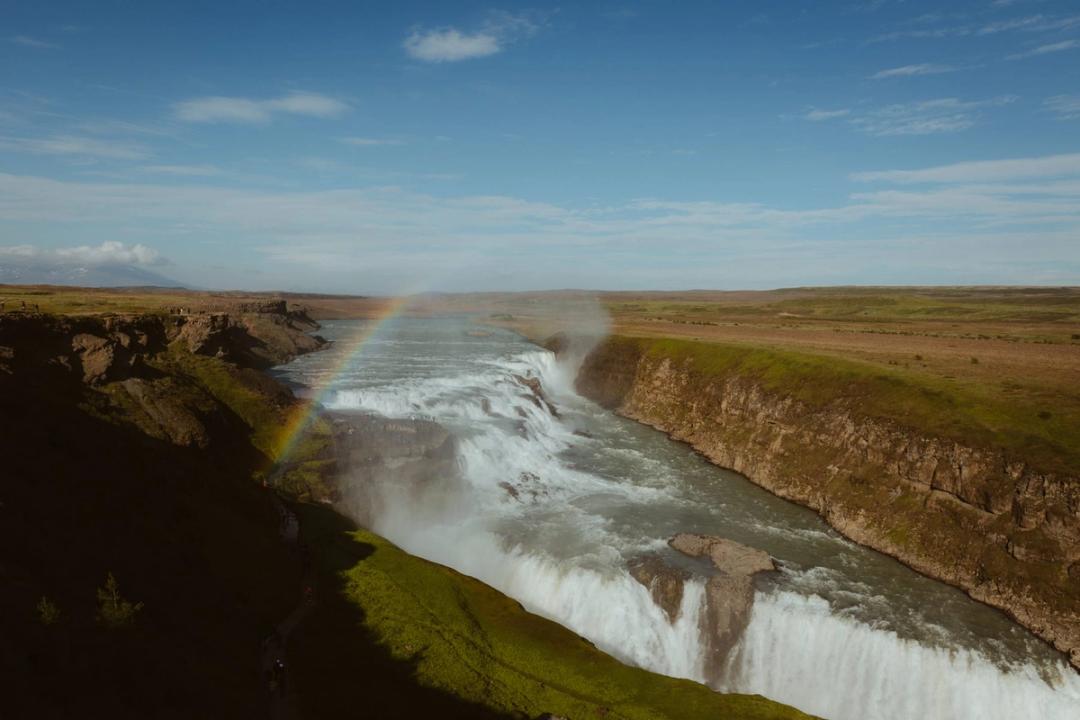Gullfoss cascading into a gorge with a rainbow in the spray.