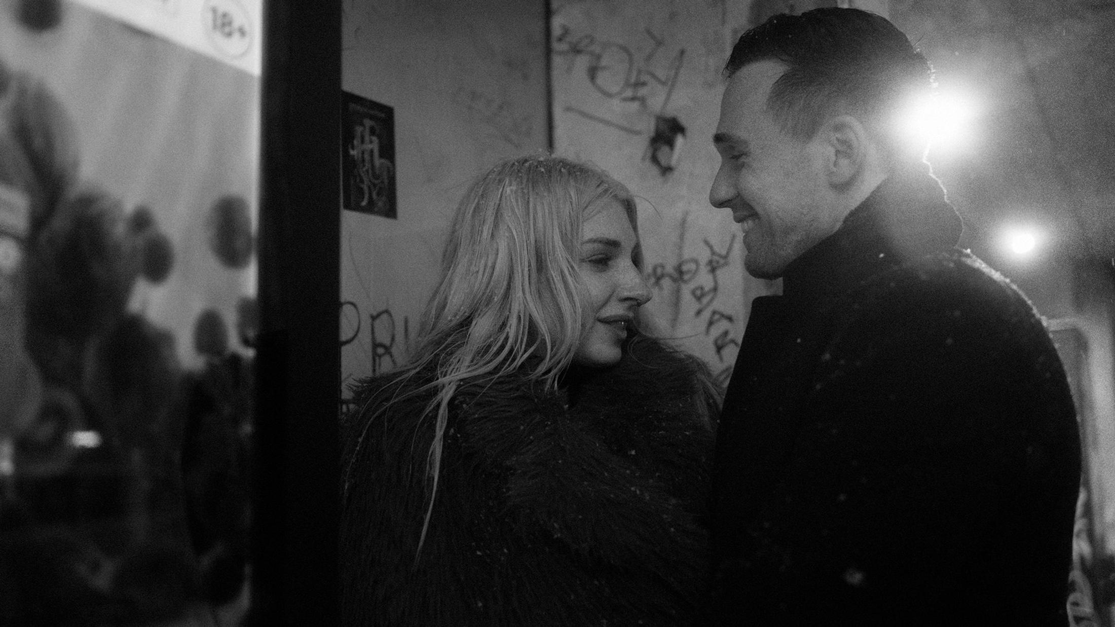 Lorelai and Steffen look at each other in falling snow on St. Pauli, in black and white.