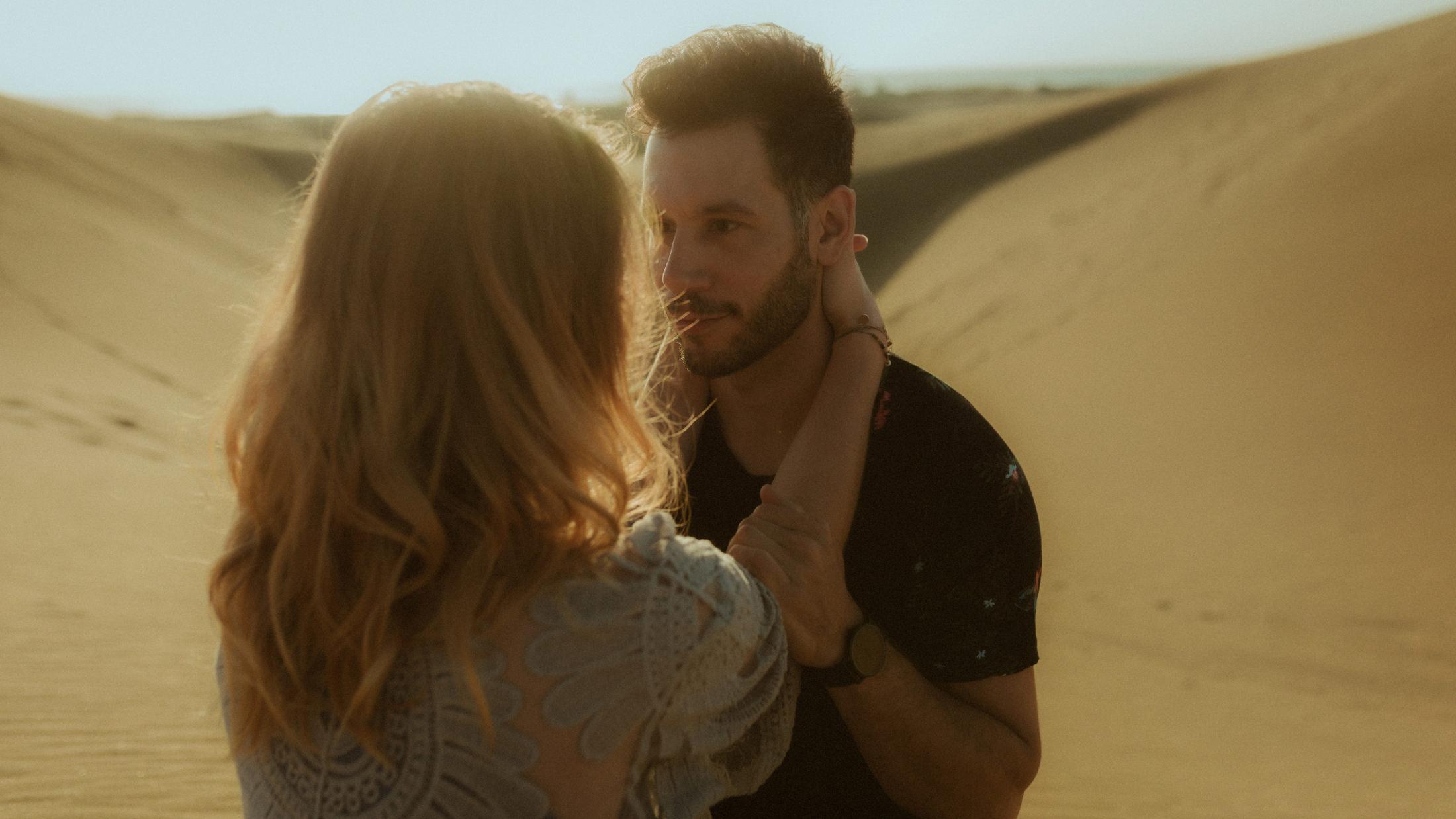 Katja touching David's face while he looks at her.