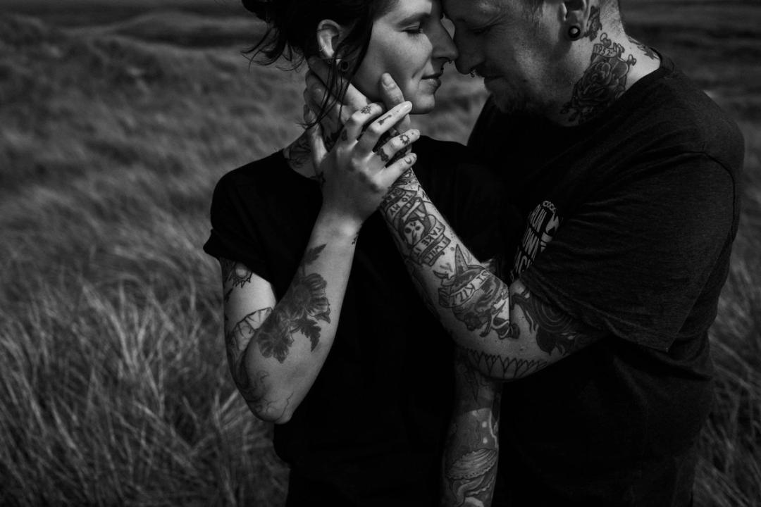 Bjørn and Jana stand forehead to forehead, holding each other by the face and hands.