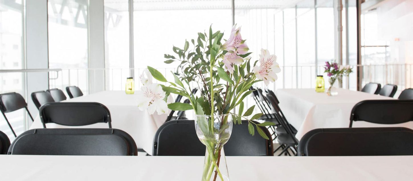 Stemningsbilde med blomster og bord og stoler.