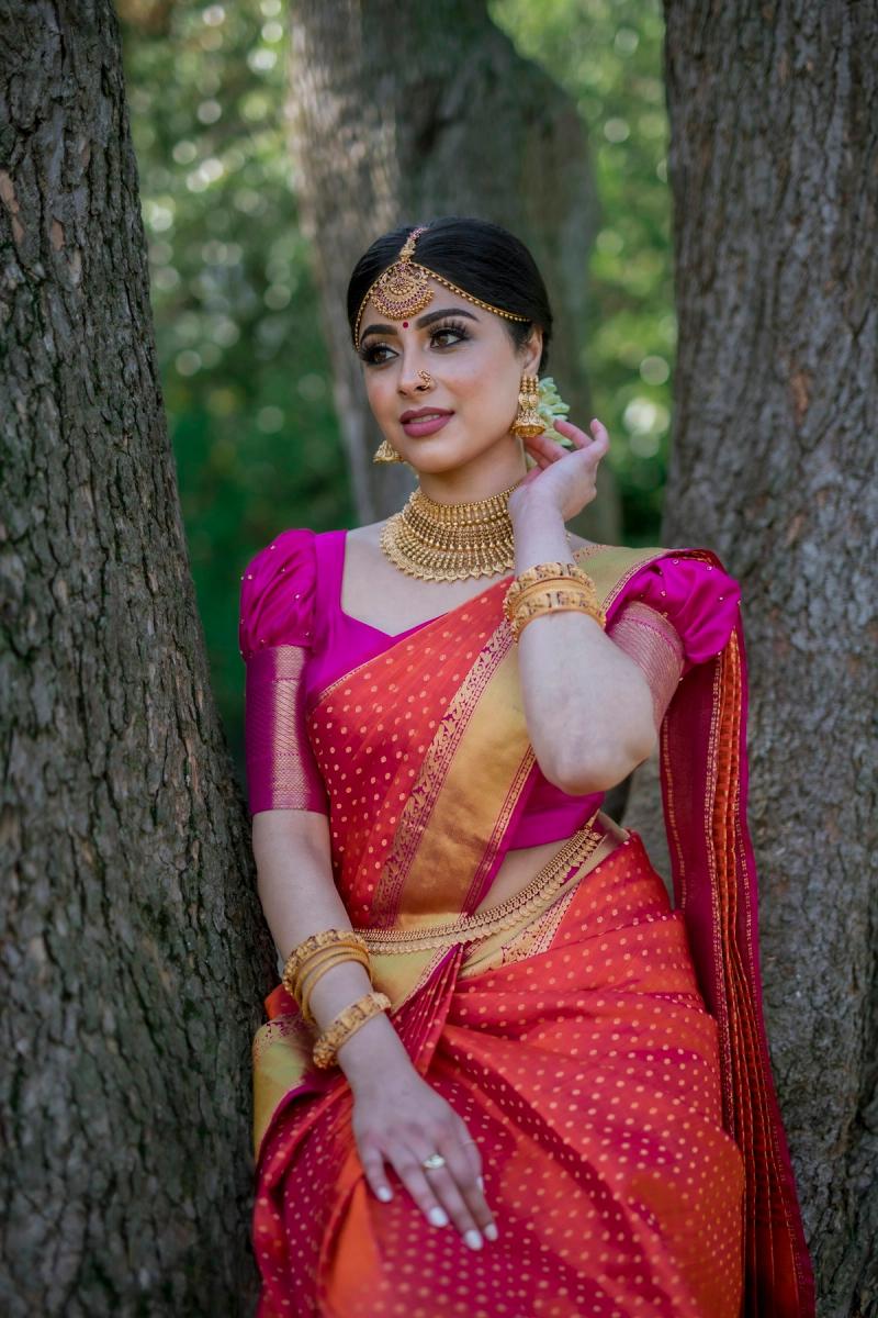 A woman in a red and blue Jamdani saree