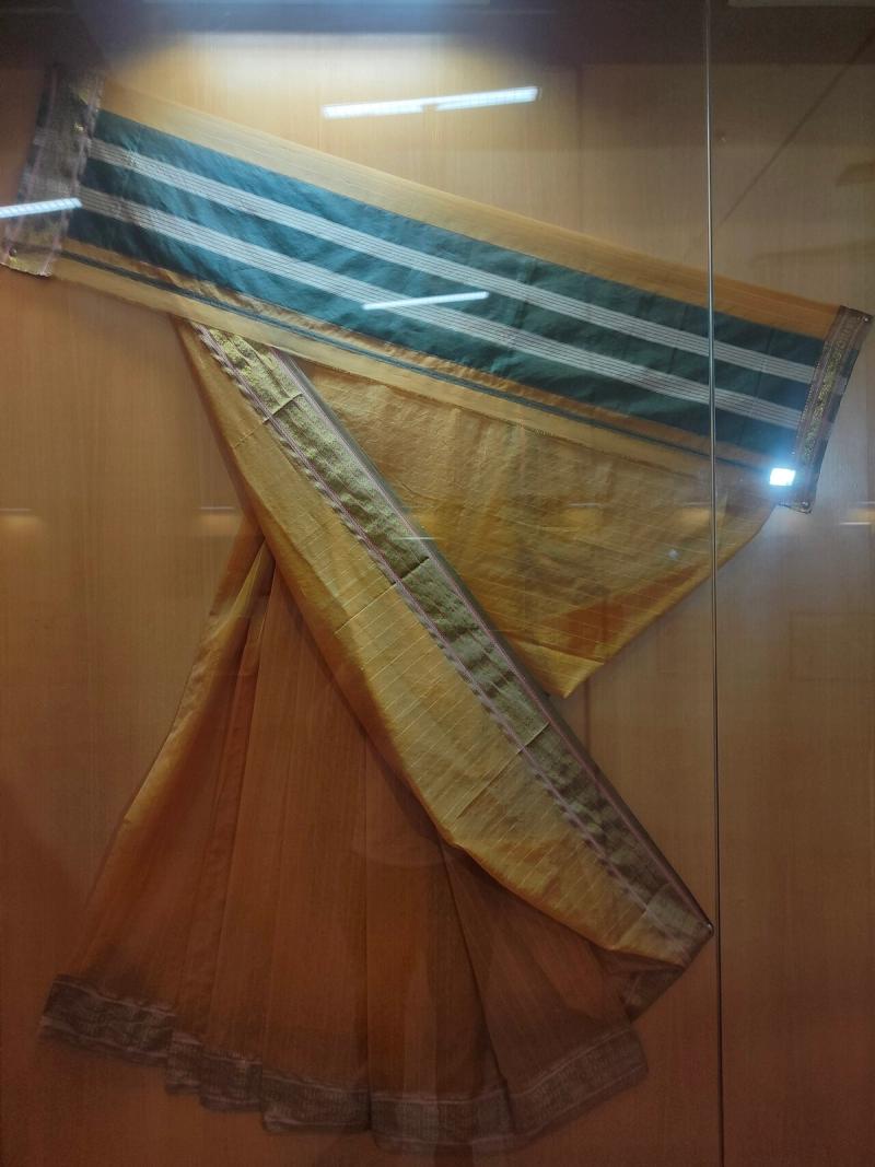 A gold Maheshwari saree with the signature striped pallu