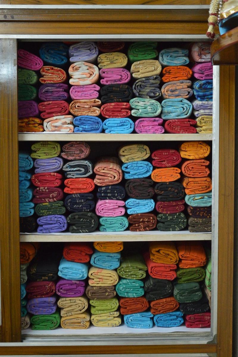 Stacks of colourful Tant cotton sarees displayed in a Phulia shop