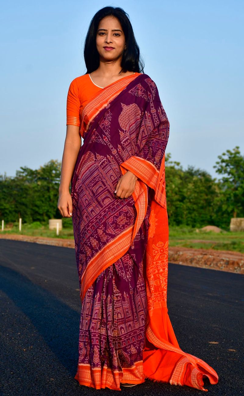 A model wearing a purple Sambalpuri ikat saree with temple motifs and an orange pallu