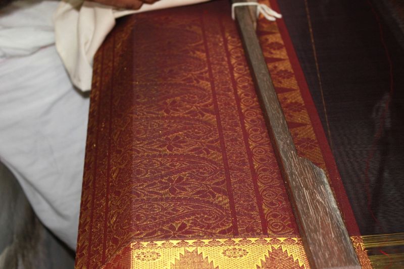 A maroon-and-gold Kanjivaram silk saree on the loom at Kanchipuram