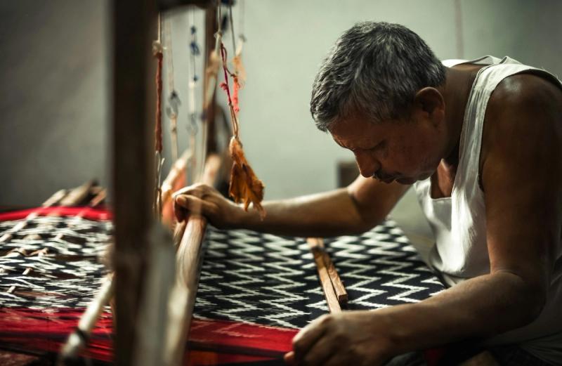 A weaver operating a traditional handloom
