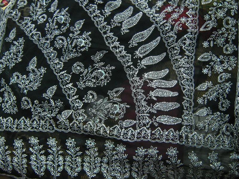 Close-up of white Chikankari embroidery on a dark cotton saree pallu