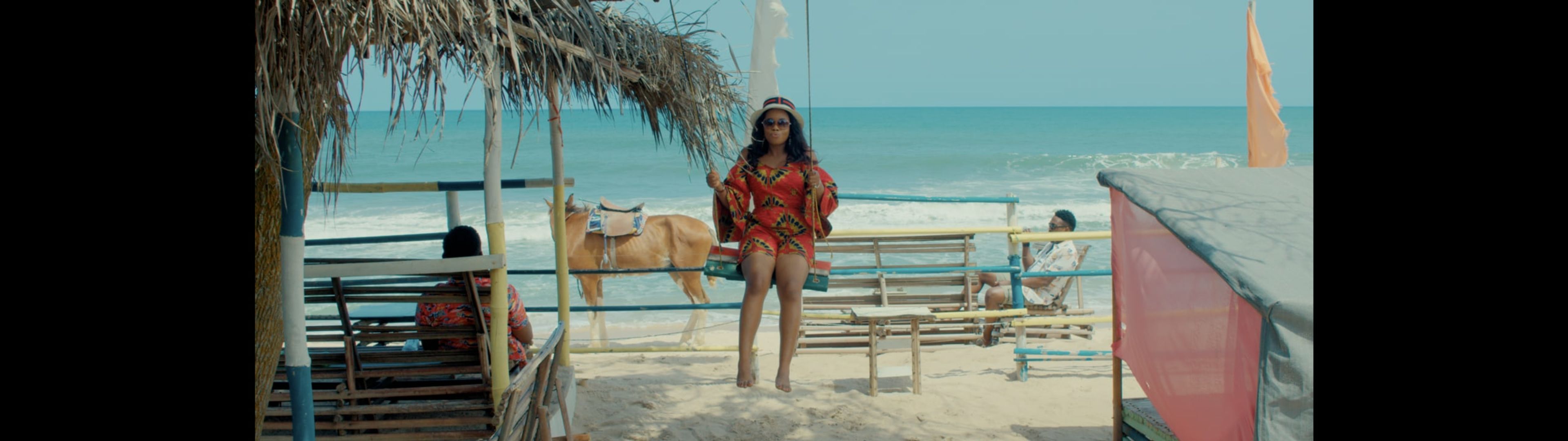 A woman in a red dress at a beachside bar