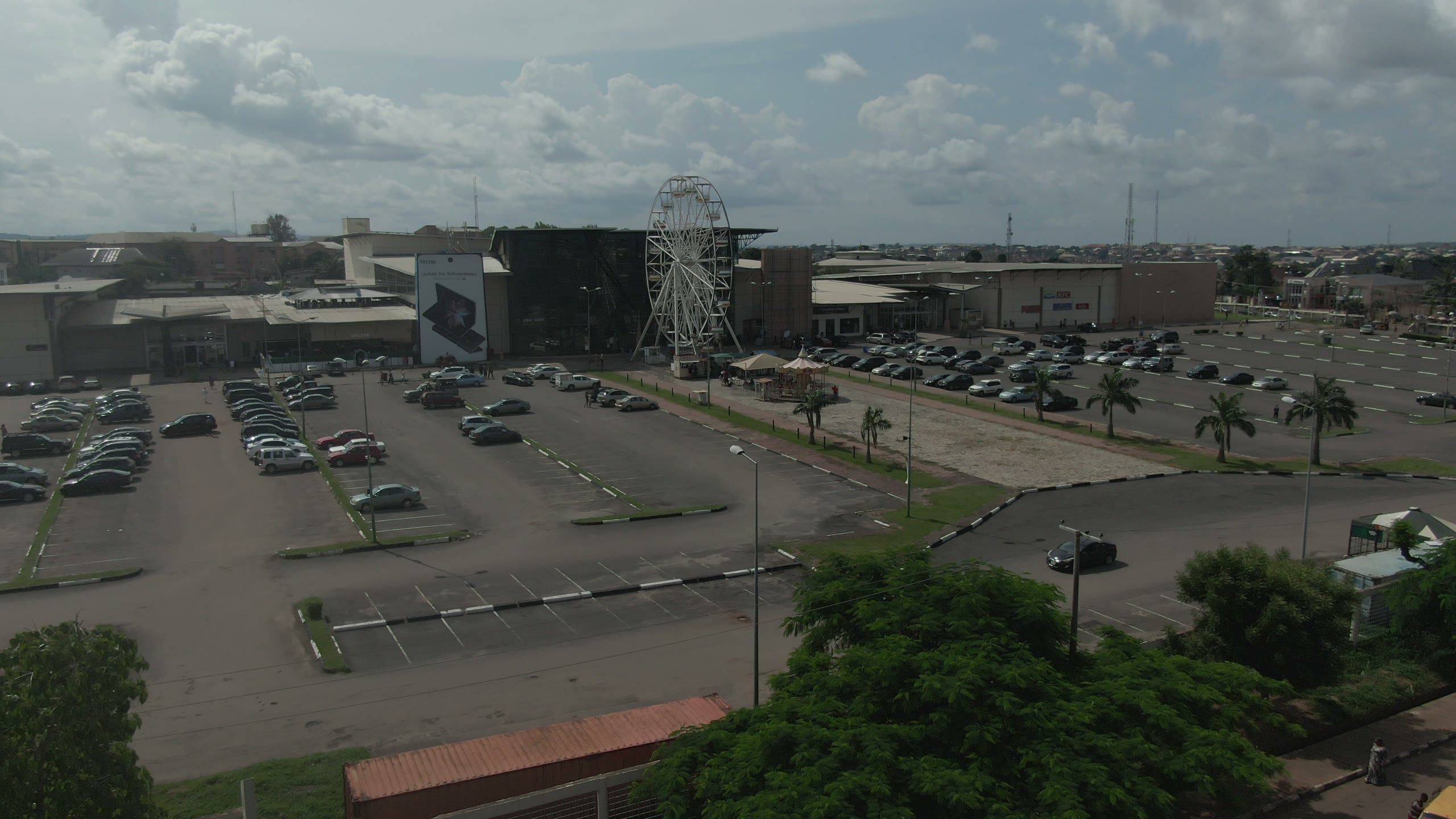 Aerial view of a shopping mall car park with a ferris wheel