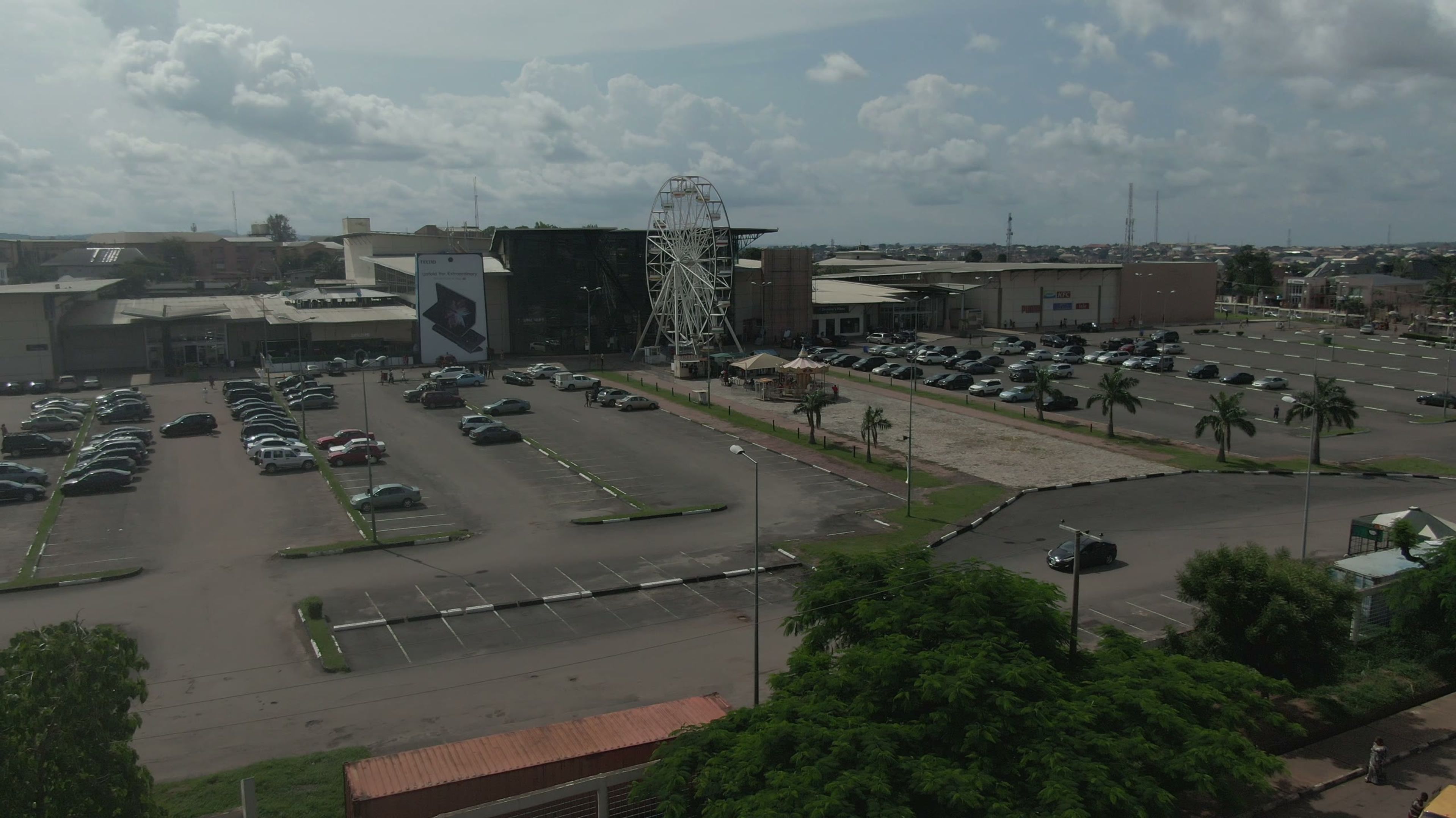 Aerial view of a shopping mall car park with a ferris wheel