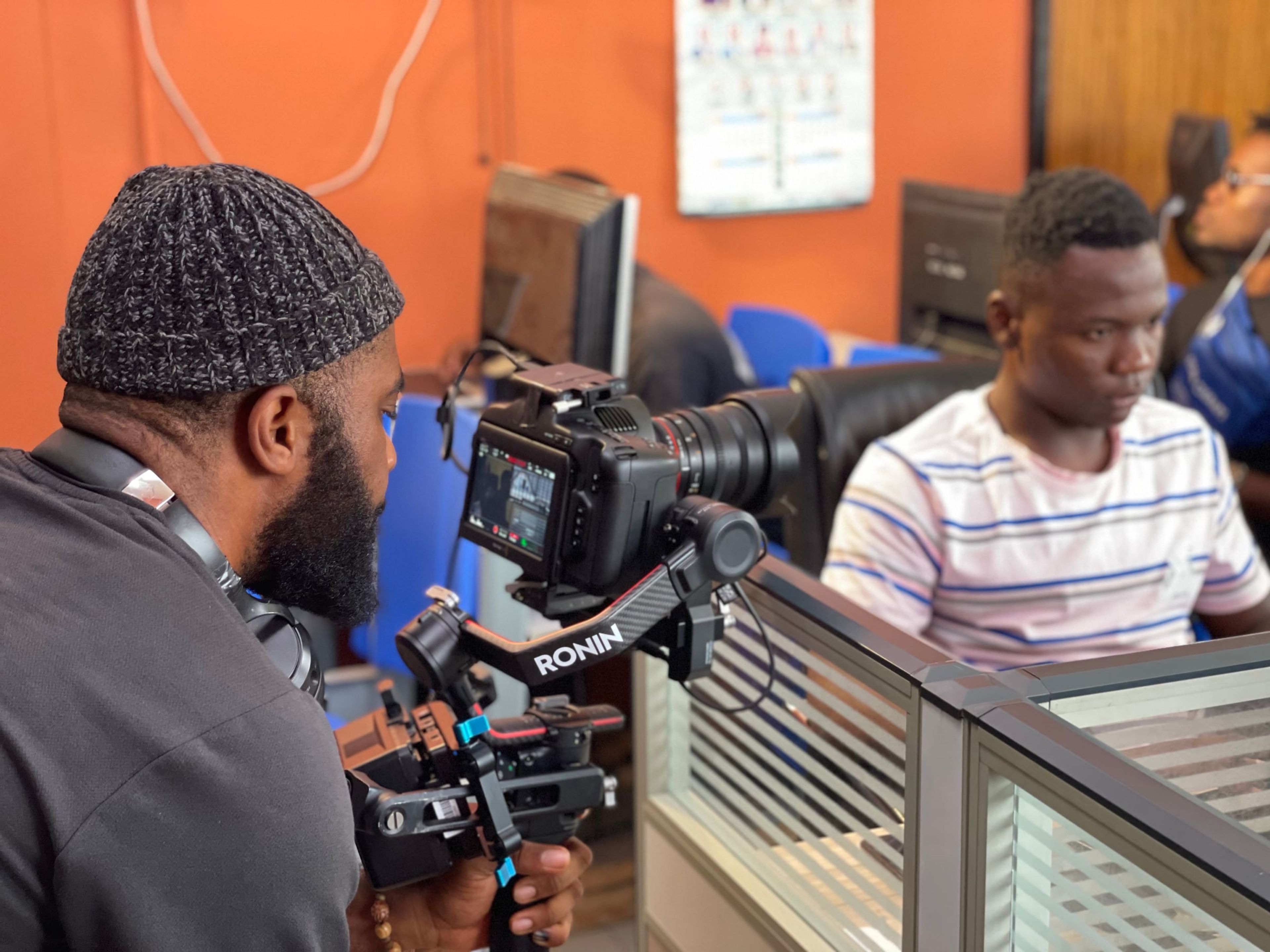 Camera operator filming a scene in an office