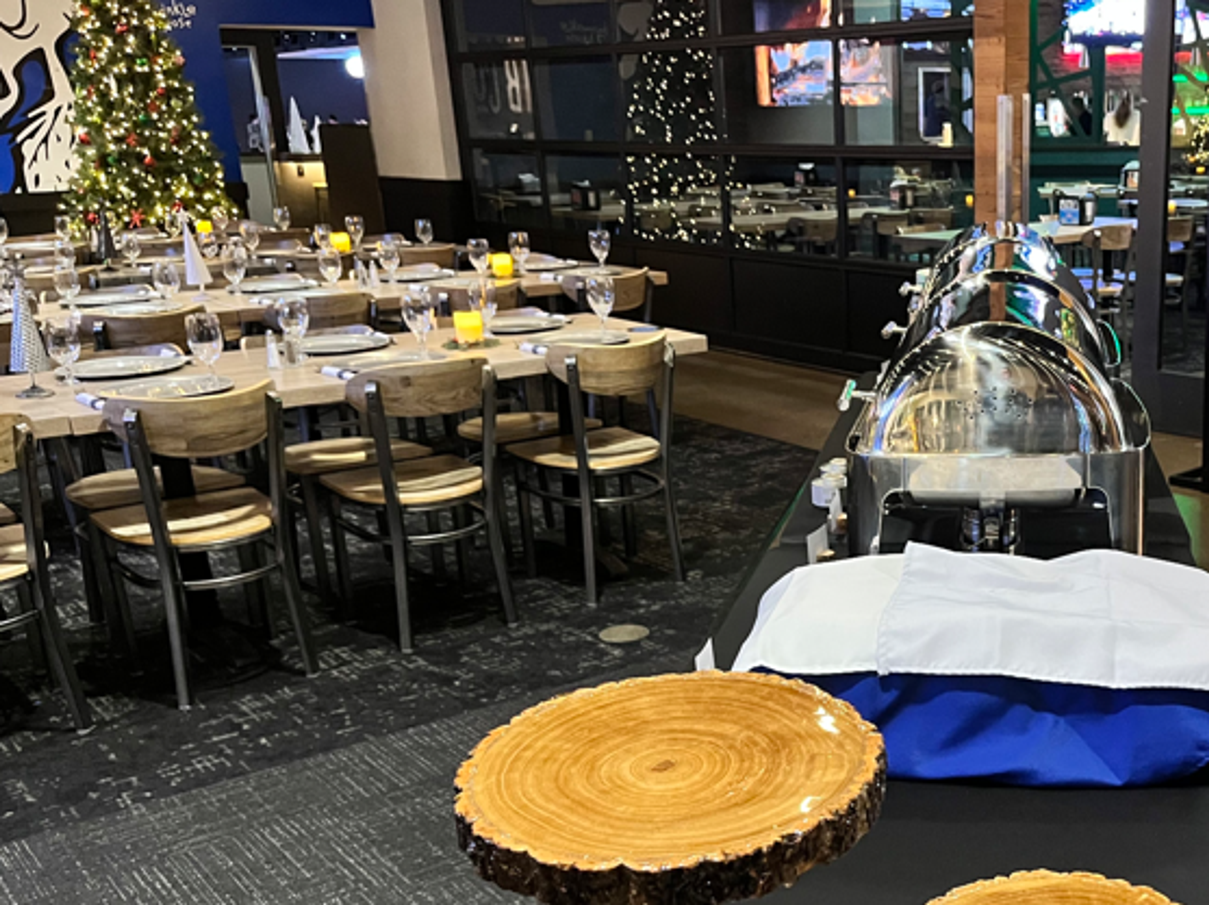 The holiday buffet station with chafing dishes set on wood-slice risers
