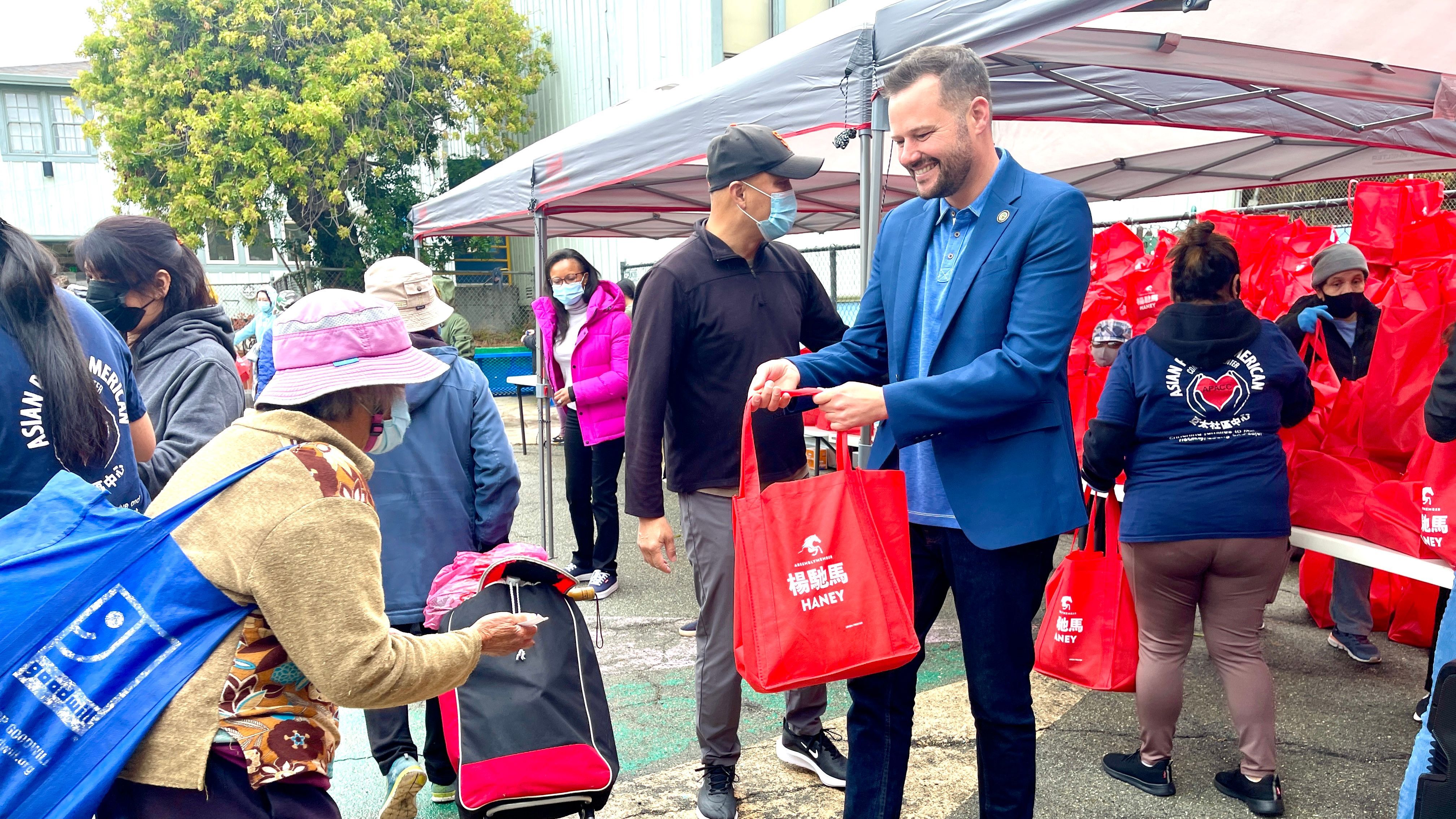 Assemblymember Matt Haney distributes 500 bags with Asian food, which are donated by the Oriental Food Association, to the elderly and low income families in Visitacion Valley. Photo by Portia Li