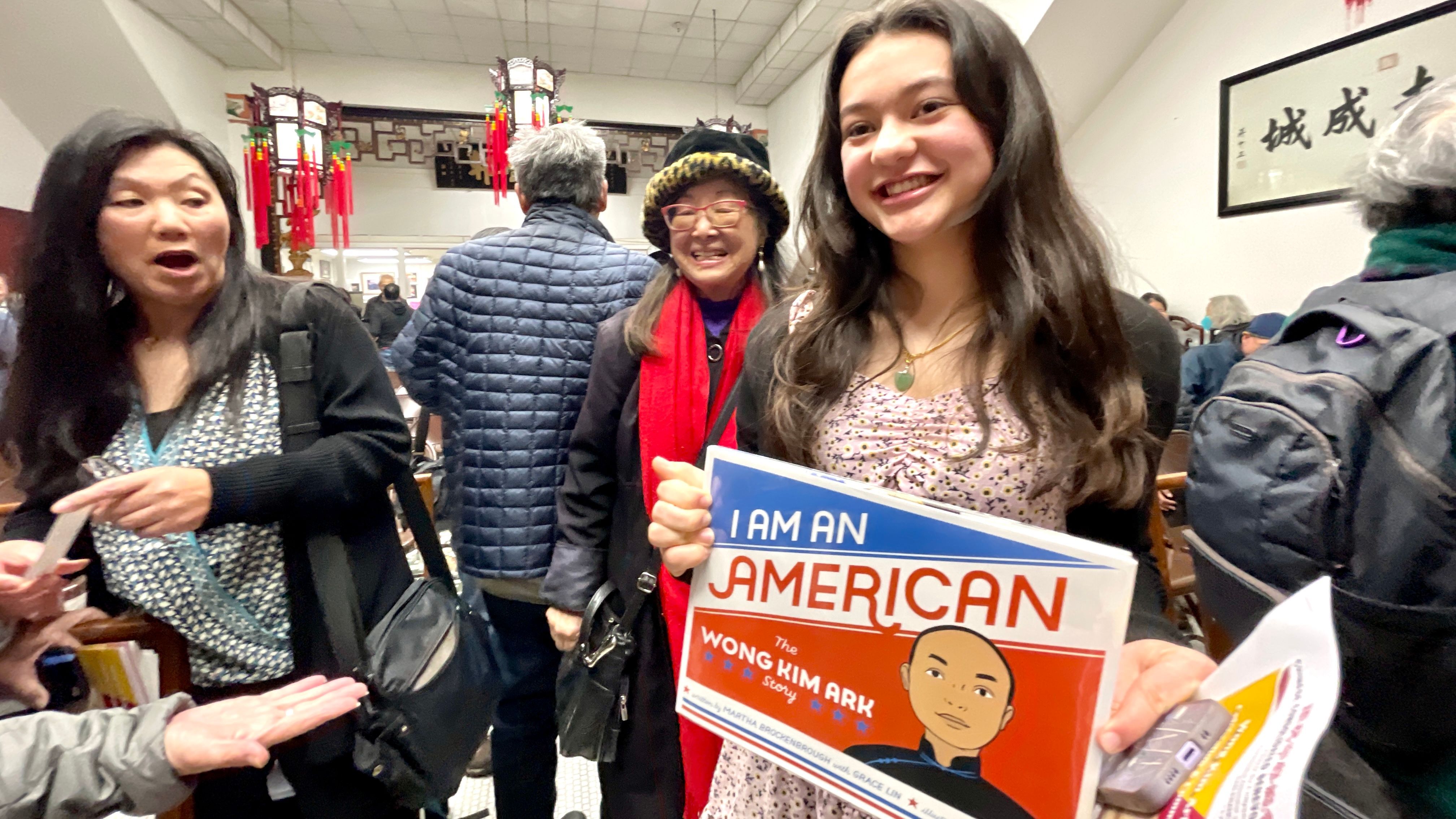 Wong Kim Ark’s 14-year-old great great granddaughter Nina (right) attends the celebration with her mom Sandra Wong (left). She holds a children book, I Am An American - The Wong Kim Ark Story, which was released in 2021.  Photo by Portia Li