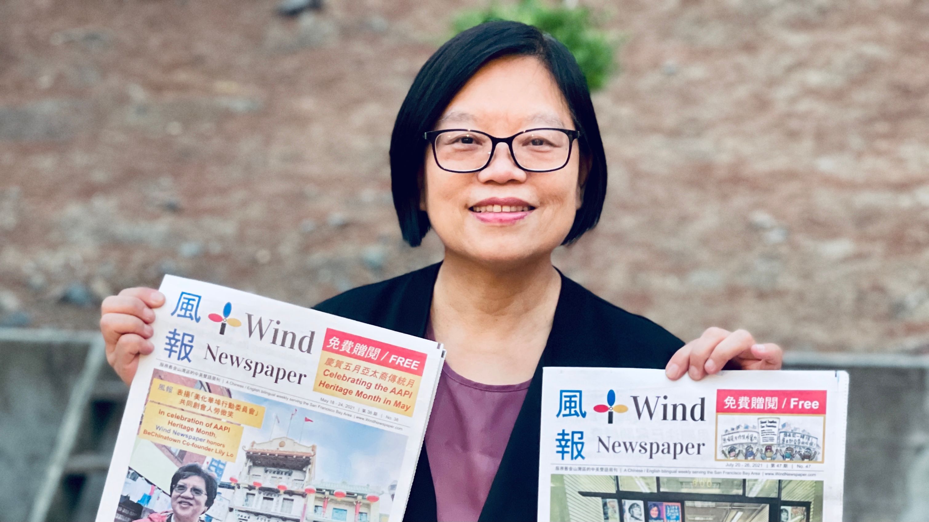 Portia Li holds up issues of Wind Newspaper, which she publishes every week about San Francisco’s Chinatown.